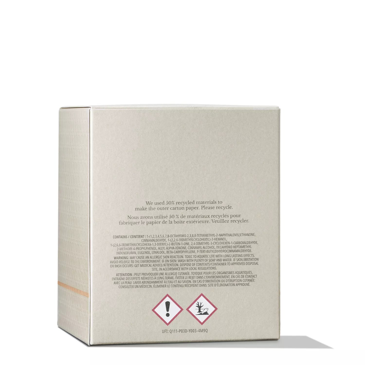 A beige cardboard box reveals the opulent scent of Molton Brown Cyprus Mesmerising Oudh Accord & Gold Signature Candle 190g. Printed text in English and French about recycled materials features below two warnings: an exclamation mark and a dead tree, all set against a white background.