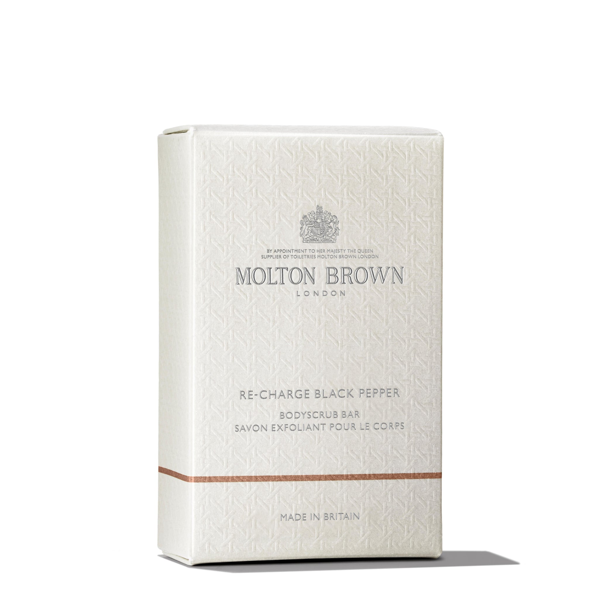 The MoltonBrown Cyprus Re-charge Black Pepper Bodyscrub Bar 250g, infused with Madagascan black peppercorn oil, is elegantly packaged in a cream-colored box. Its name is displayed with subtle text alongside a small emblem, and "Made in Britain" is noted at the bottom.