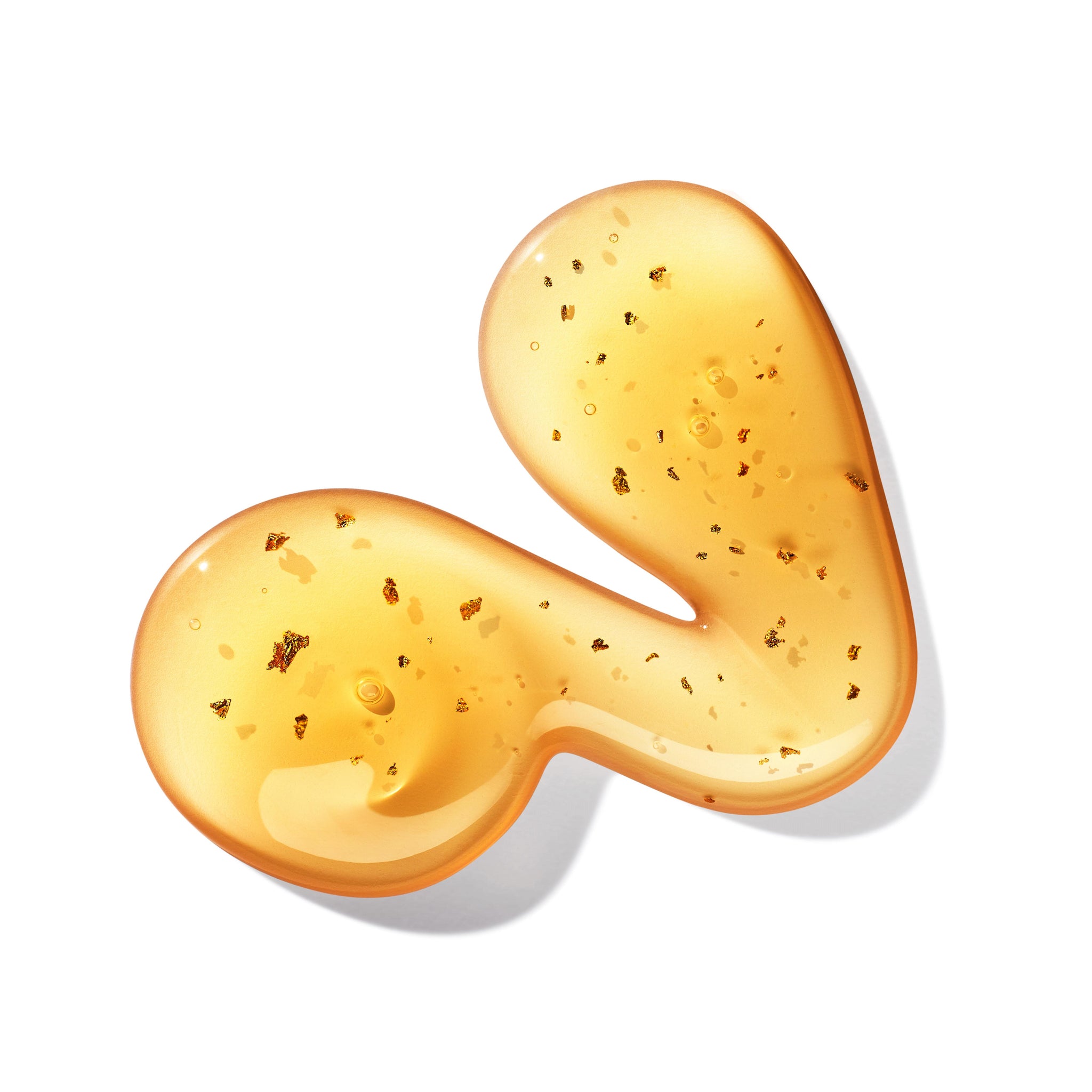 A close-up of the glossy Mesmerising Oudh Accord & Gold Bath & Shower Gel by MoltonBrown Cyprus, showcasing an abstract S shape in amber with tiny gold flakes, reminiscent of spiced forest luxury, set against a white background.