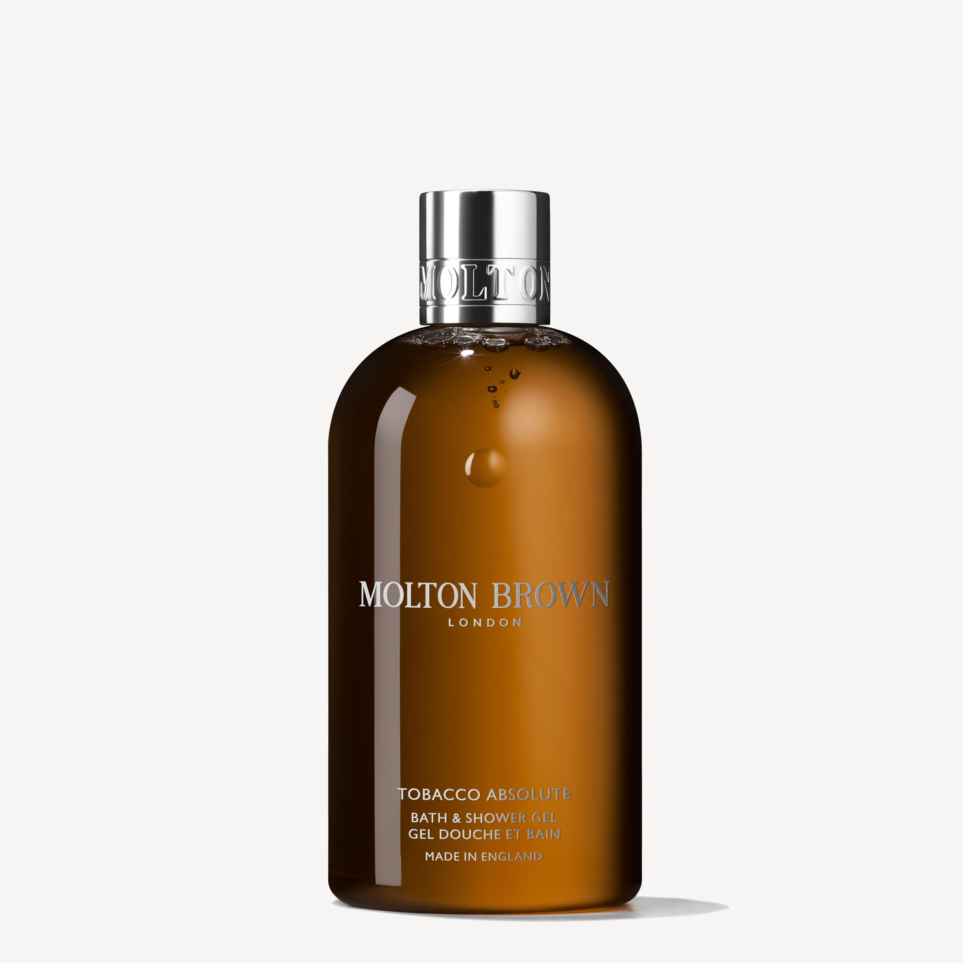A 300ml brown bottle of MoltonBrown Cyprus Tobacco Absolute Bath & Shower Gel features a silver cap and is infused with rich cedarwood and spicy-citrus elemi. The label displays the brand name and product details in white text against a plain white background.