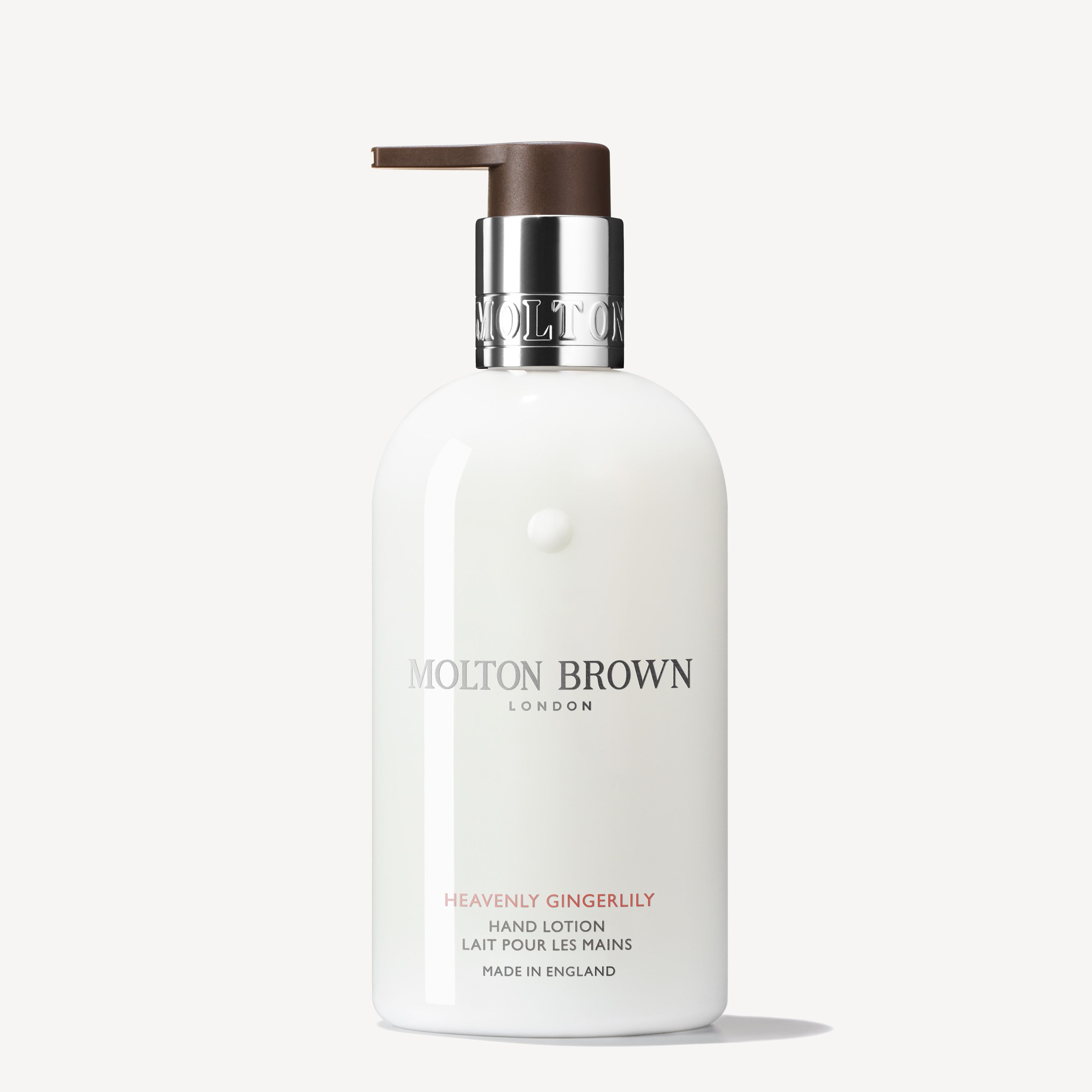 A 300ml bottle of MoltonBrown Cyprus Heavenly Gingerlily Hand Lotion with a pump dispenser, offering an exotic fragrance. The bottle has a white label adorned with silver and light brown text, featuring the brand logo and product details presented in both English and French.