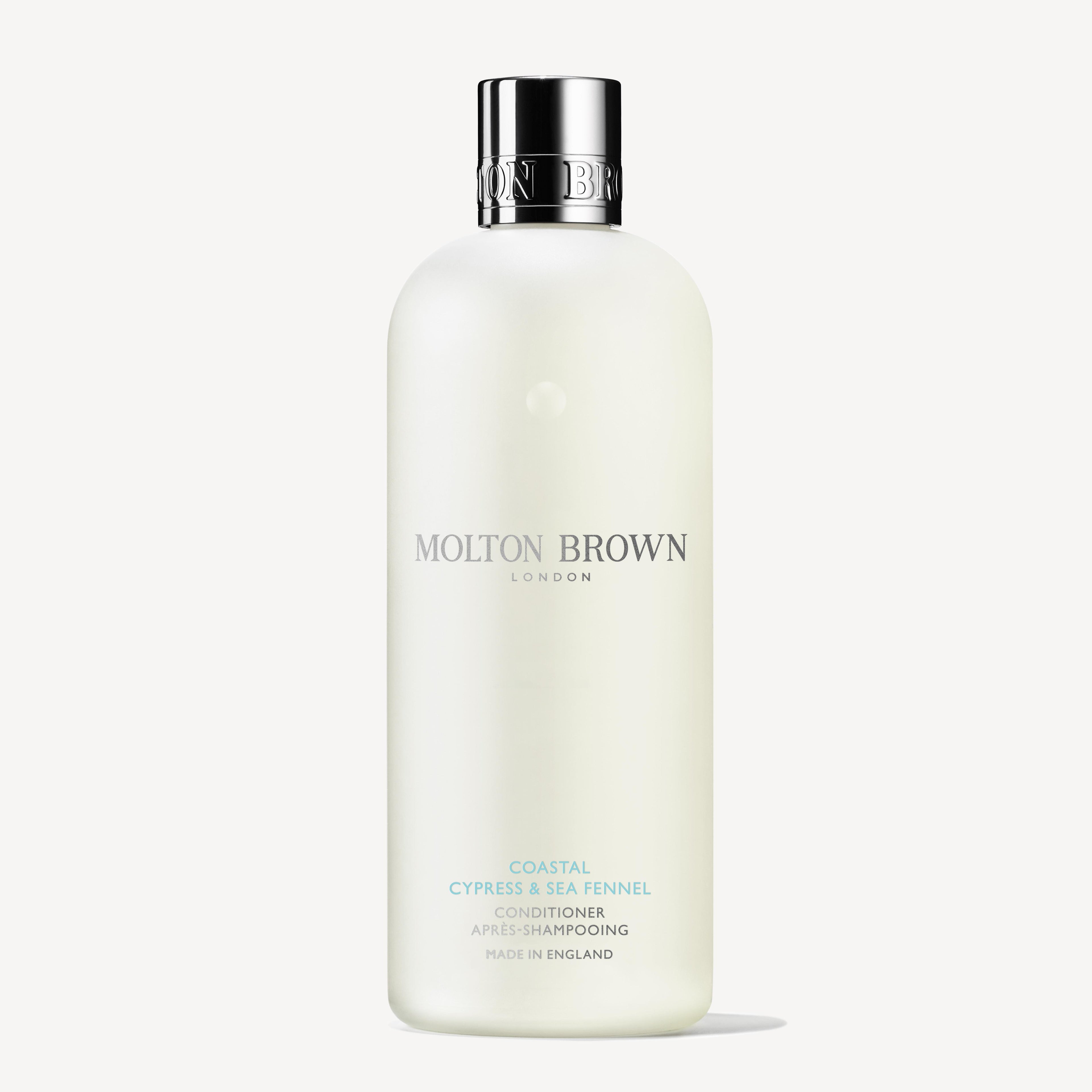 A 300ml bottle of Molton Brown Cyprus Coastal Cypress & Sea Fennel Conditioner stands upright with a silver cap and minimalist white label, set against a white background—ideal for all hair types.