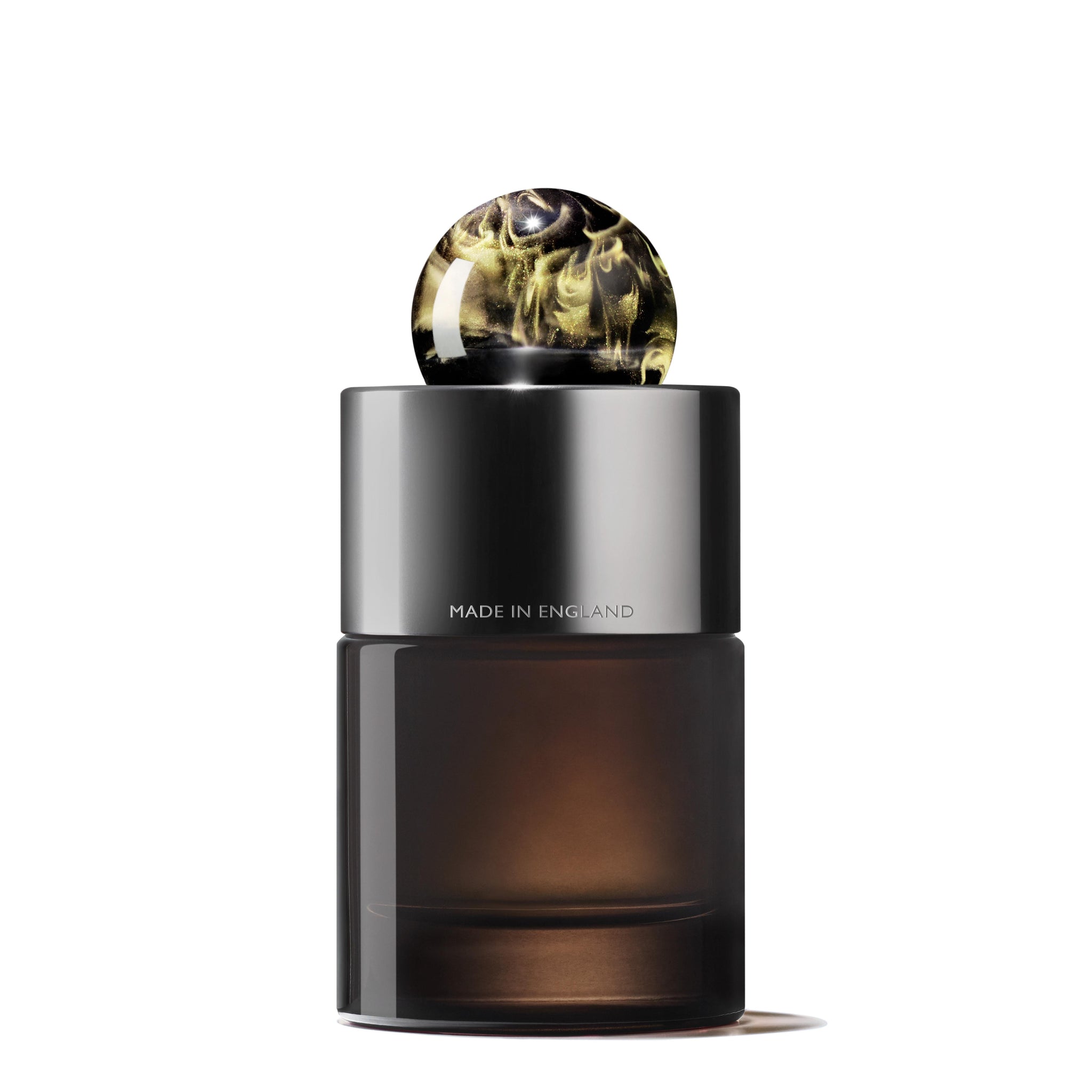 The Labdanum Dusk Eau de Parfum by MoltonBrown Cyprus features a sleek 100ml bottle with a dark, translucent body and a black cylindrical cap adorned with an elegant marbled pattern in shades of white and black, hinting at the rare oudh essence inside. "Made in England" is elegantly inscribed on the bottle's surface.