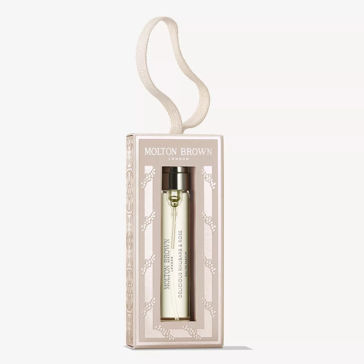The MoltonBrown Cyprus Delicious Rhubarb & Rose Fragrance Bauble 7.5ml is showcased in a beige patterned box with a looped ribbon for hanging, featuring a gold bottle inside.