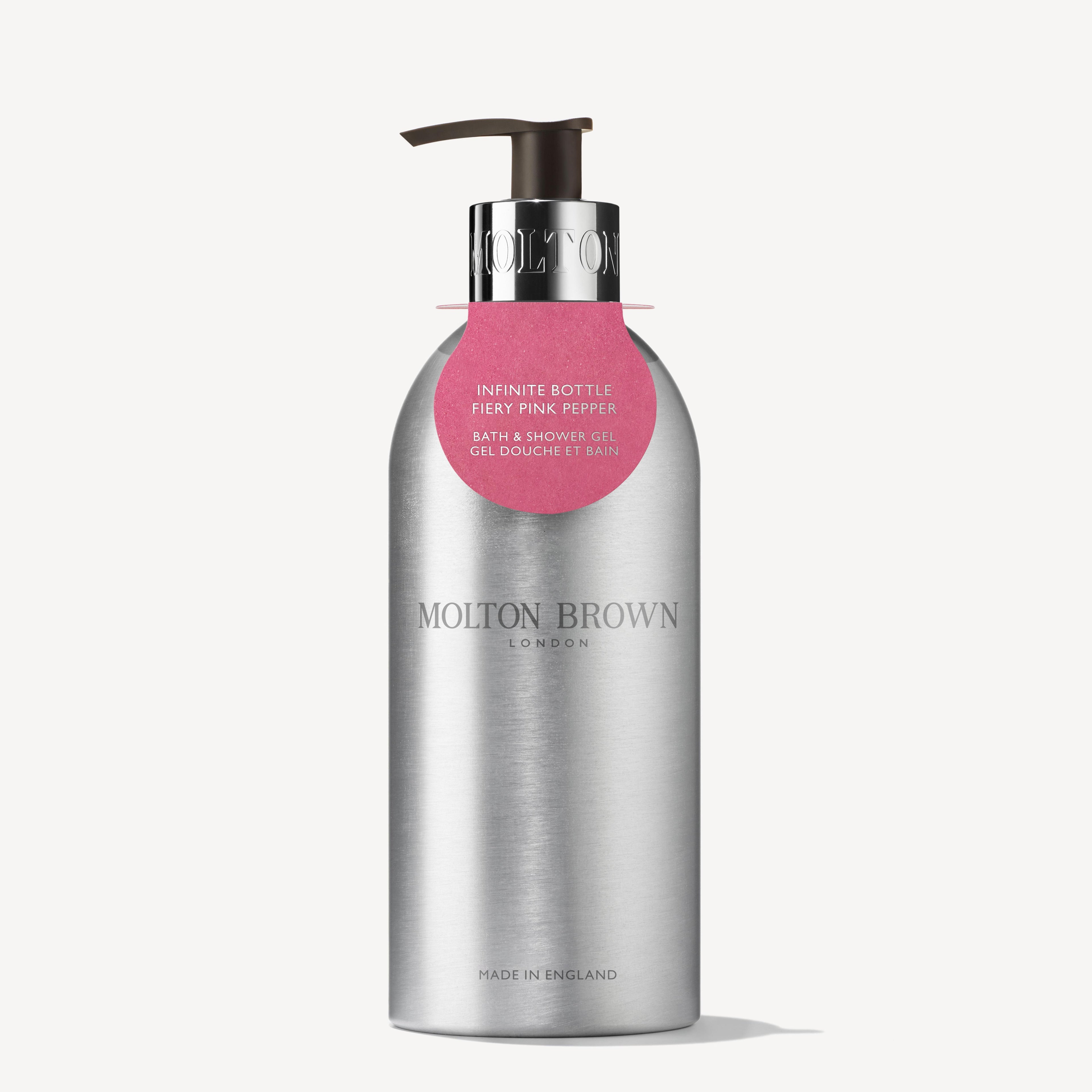 MoltonBrown Cyprus presents the Fiery Pink Pepper Infinite Bottle 400ml, a sleek silver pump bottle crafted from recycled aluminum. This woody-spicy body wash features a minimalist design with a small pink label and is a sustainable choice made in England.