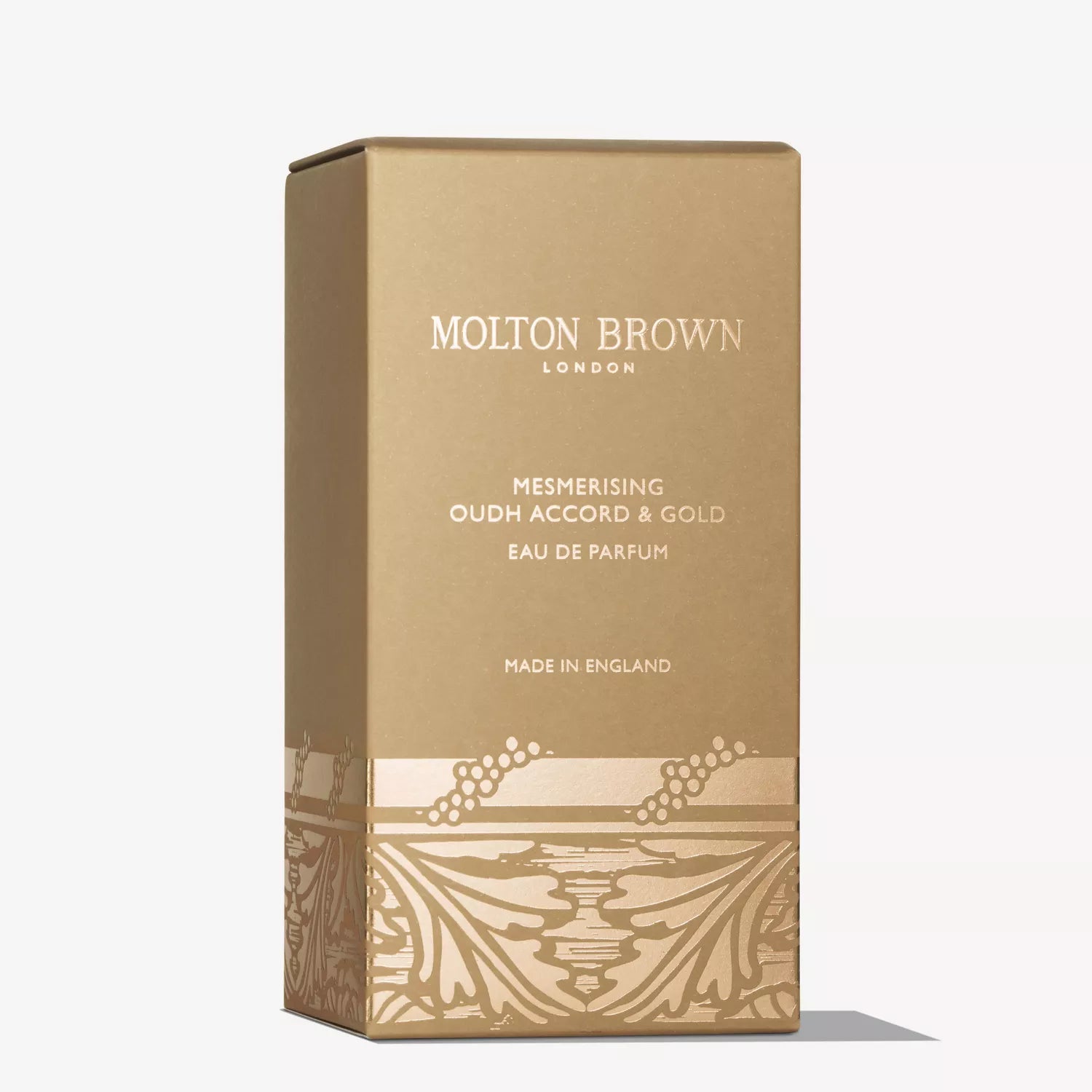 A gold rectangular box of MoltonBrown Cyprus Limited Edition Mesmerising Oudh Accord & Gold Eau de Parfum 100ml, adorned with elegant white and gold text and decorative lower patterns.