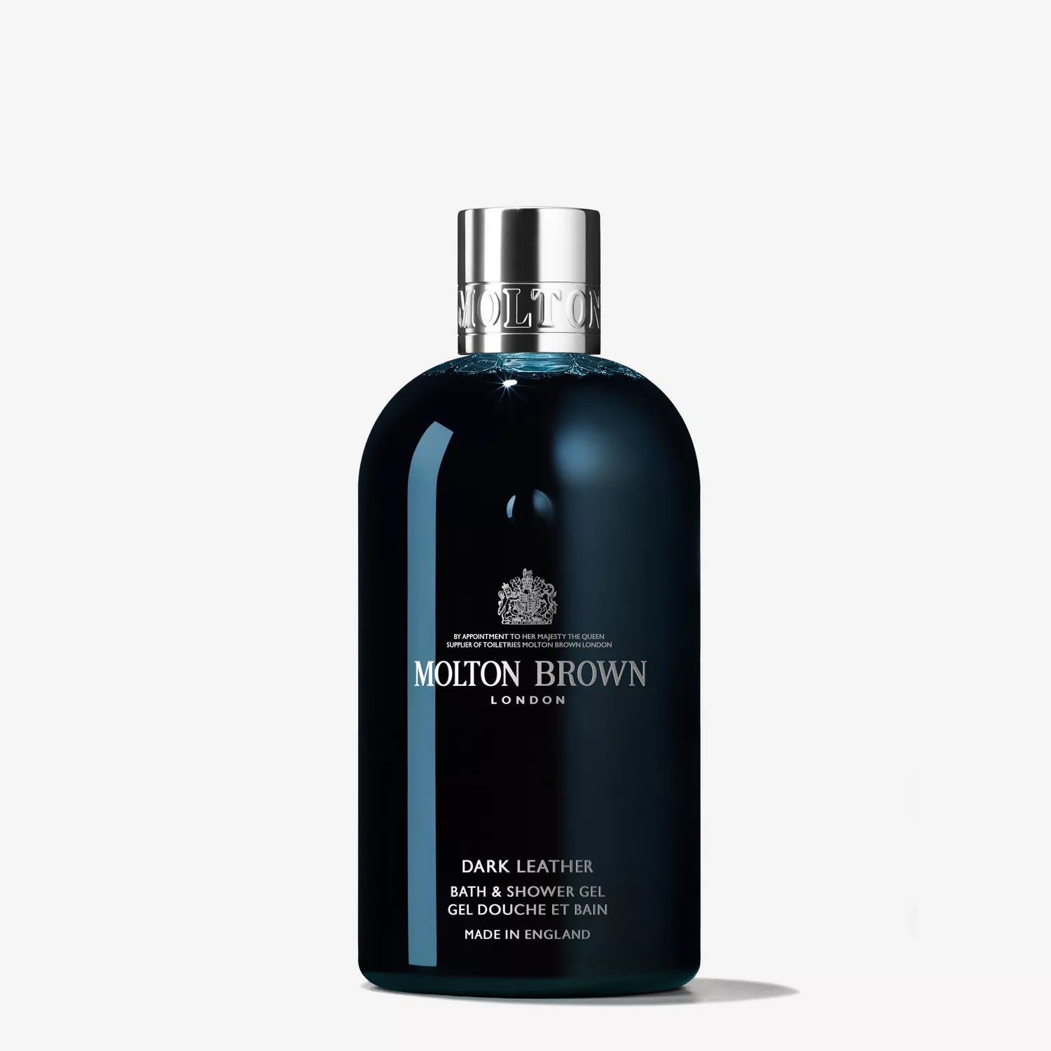 The Woody Gift Set from MoltonBrown Cyprus includes a Dark Leather Bath & Shower Gel in a sleek dark blue bottle with a silver cap and label, highlighting its English heritage and luxurious branding for a sensory indulgence.