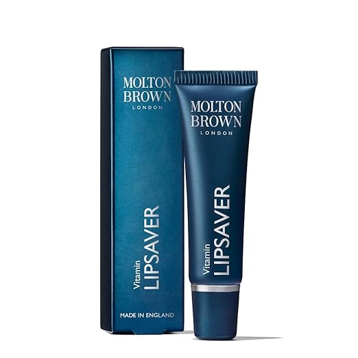 A blue tube labeled Molton Brown Cyprus Vitamin Lipsaver 10ml sits beside its matching box on a white background. Infused with nourishing vitamin E, this English-made lip balm promises to keep your lips soft and hydrated.