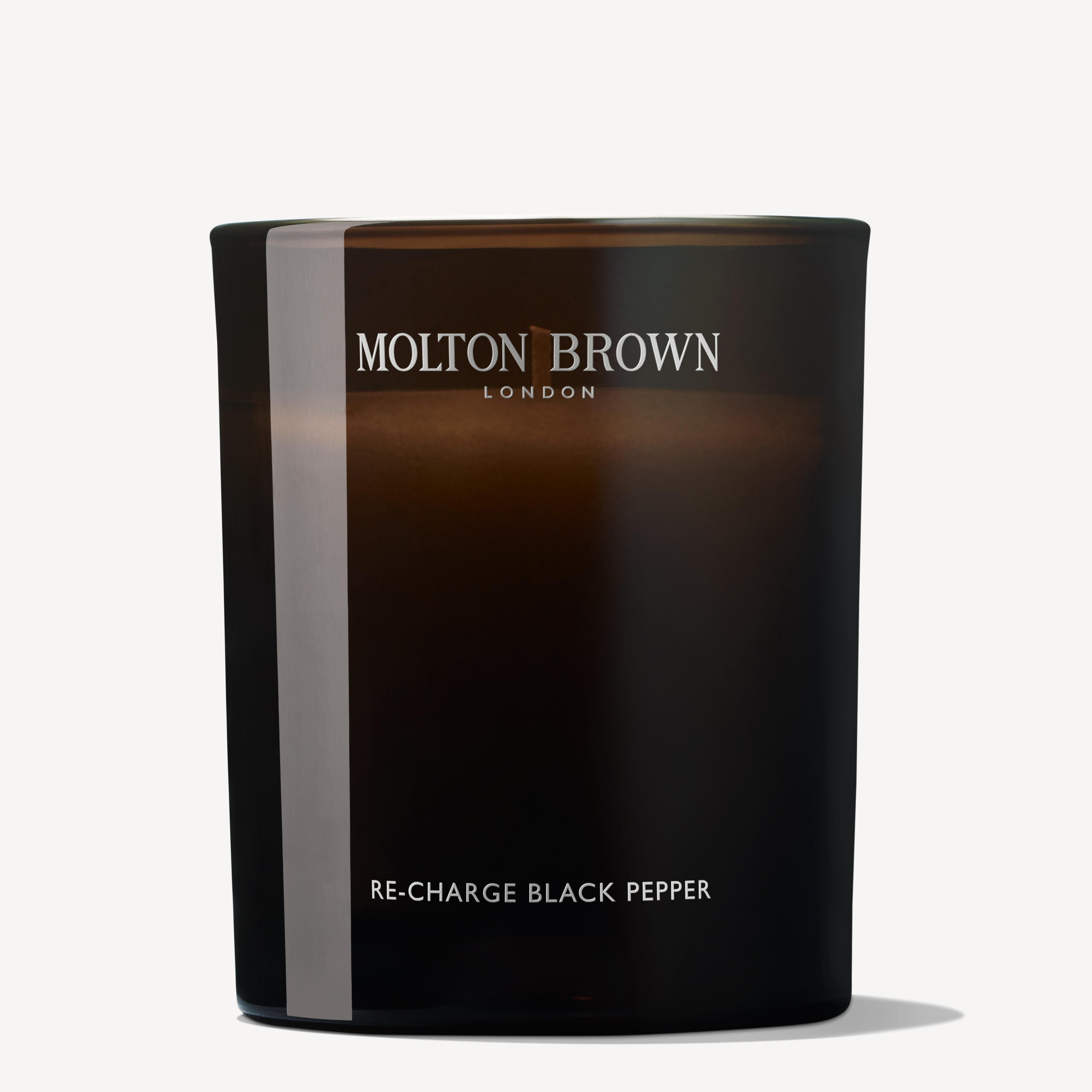 The Re-charge Black Pepper Signature Candle 190g by MoltonBrown Cyprus is a dark brown scented delight that revitalizes the senses with its simple and elegant design featuring minimal text. Infused with Madagascan black pepper, it offers a sophisticated aromatic experience.