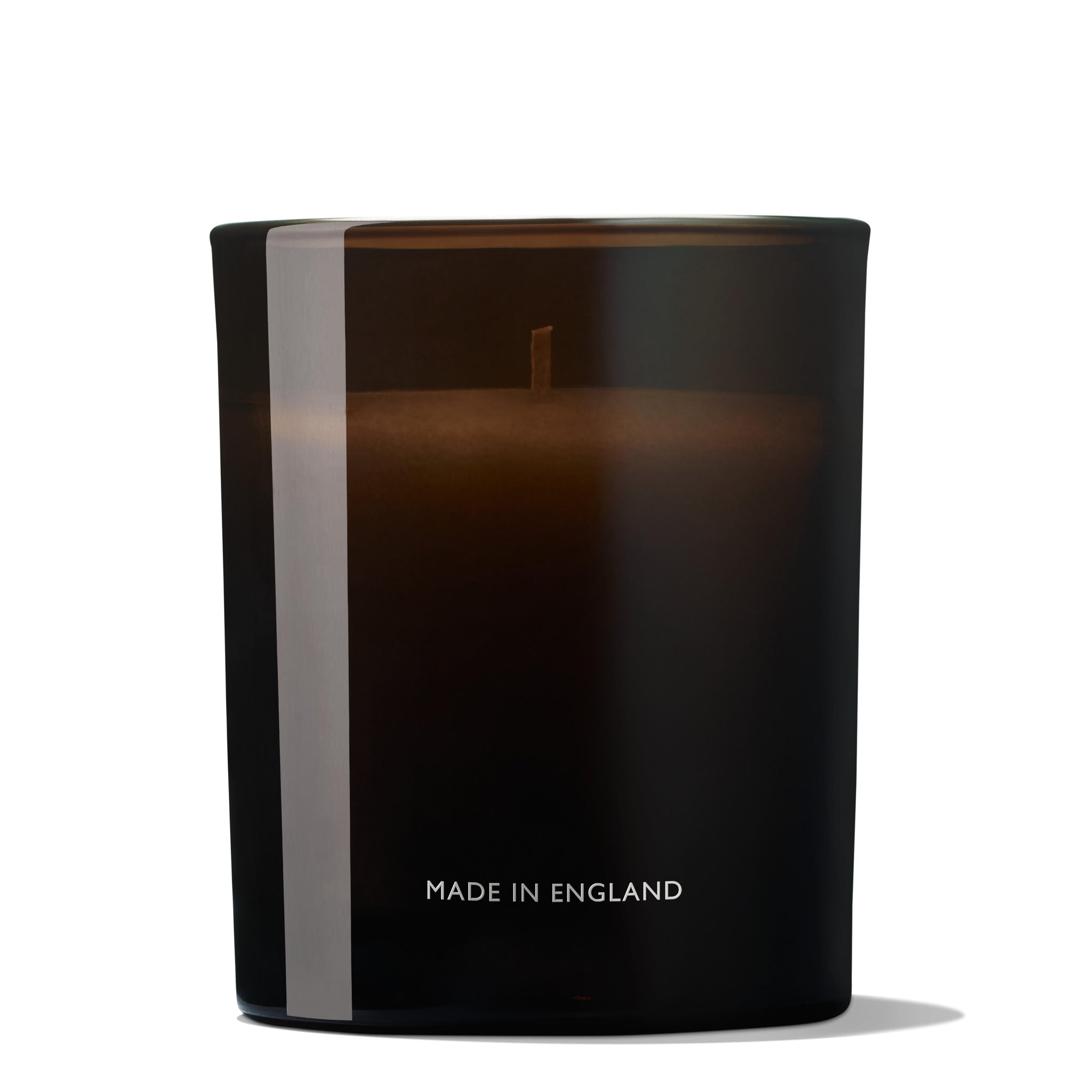 Introducing the Re-charge Black Pepper Signature Candle 190g by MoltonBrown Cyprus, a black scented candle housed in a dark glass holder with "Made in England" elegantly inscribed on it. This minimalistic design features a single wick and is infused with Madagascan black pepper to rejuvenate the senses with its captivating aroma.