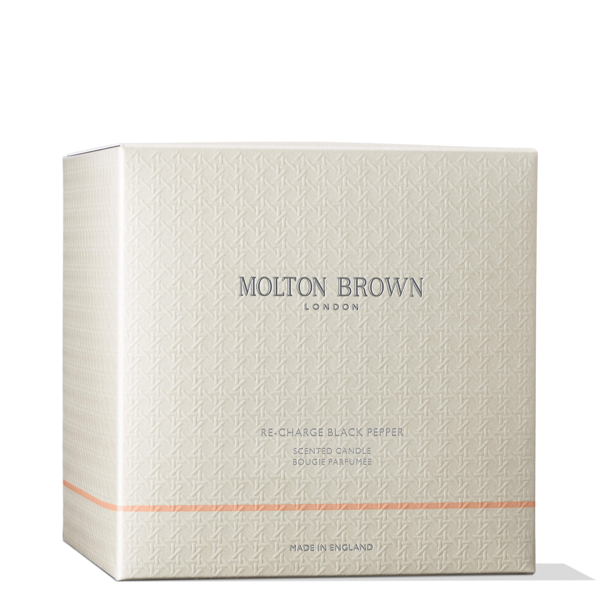 A square, textured cream box made from recycled materials showcases the MoltonBrown Cyprus text centrally. Beneath this, it introduces the Re-charge Black Pepper Luxury Candle 600g. The design is simple and elegant, with a subtle horizontal orange line near the bottom for emphasis.