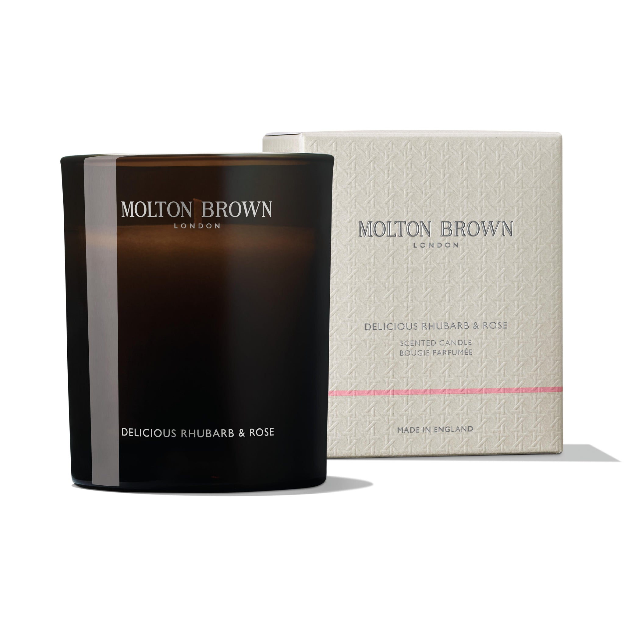 A black MoltonBrown Cyprus Delicious Rhubarb & Rose Signature Candle 190g is positioned next to its matching beige box, adorned with white text and a delicate pattern. This floral-fruity scent belongs to the MoltonBrown London collection.