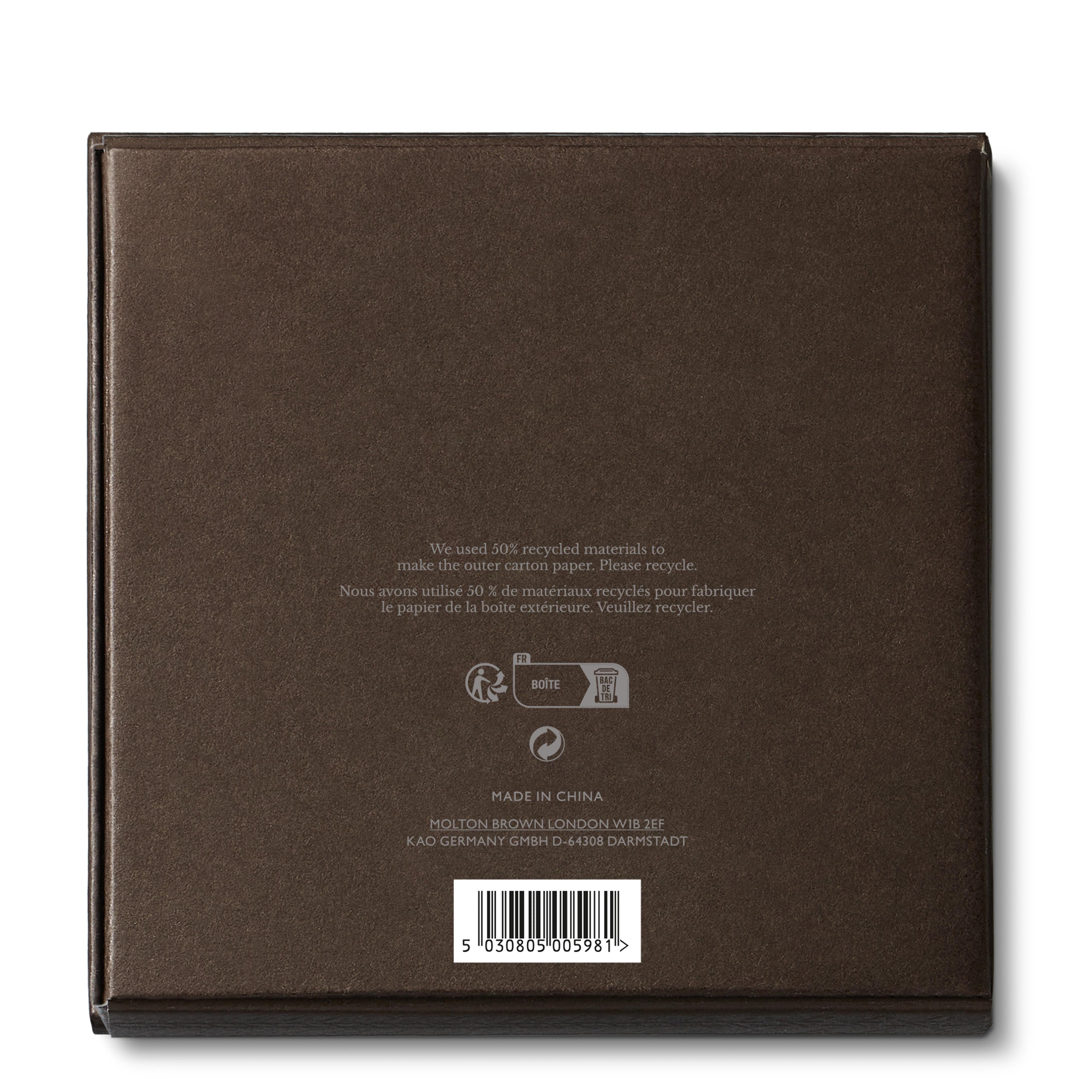 The image displays the back of a dark brown product box for the Luxury Candle Lid 154g by MoltonBrown Cyprus. It includes English and French text mentioning the use of 50% recycled materials and offering recycling instructions. The box features recycling symbols alongside a heritage rattan pattern design. It is made in China, with company addresses in London and Germany.