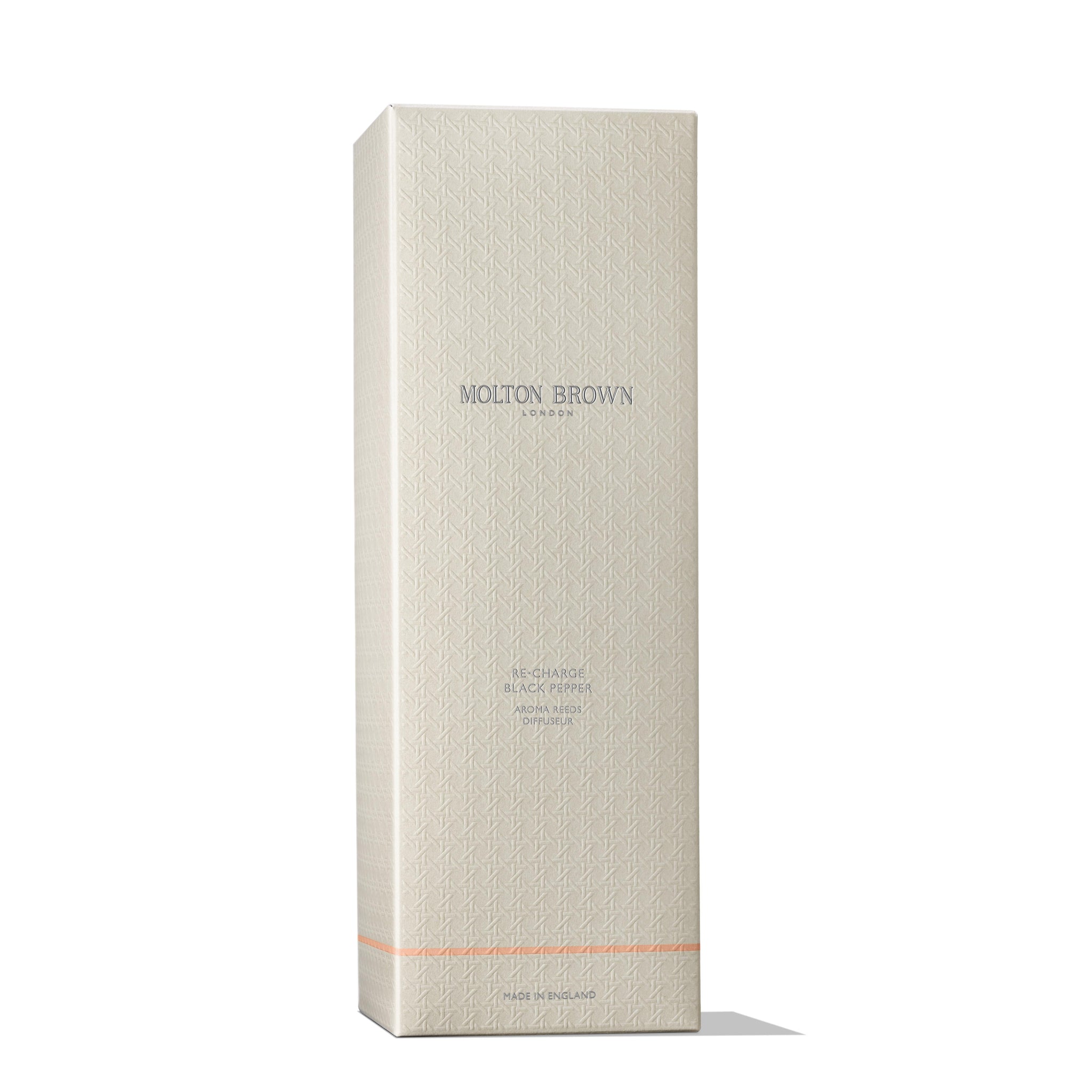 A tall, rectangular beige box displays a subtle geometric design alongside the MoltonBrown Cyprus logo in silver. Near the base is a small orange line, signifying the Re-charge Black Pepper Aroma Reeds 150ml, with its exotic Madagascan black pepper notes and woody-citrus hints, proudly crafted in England.