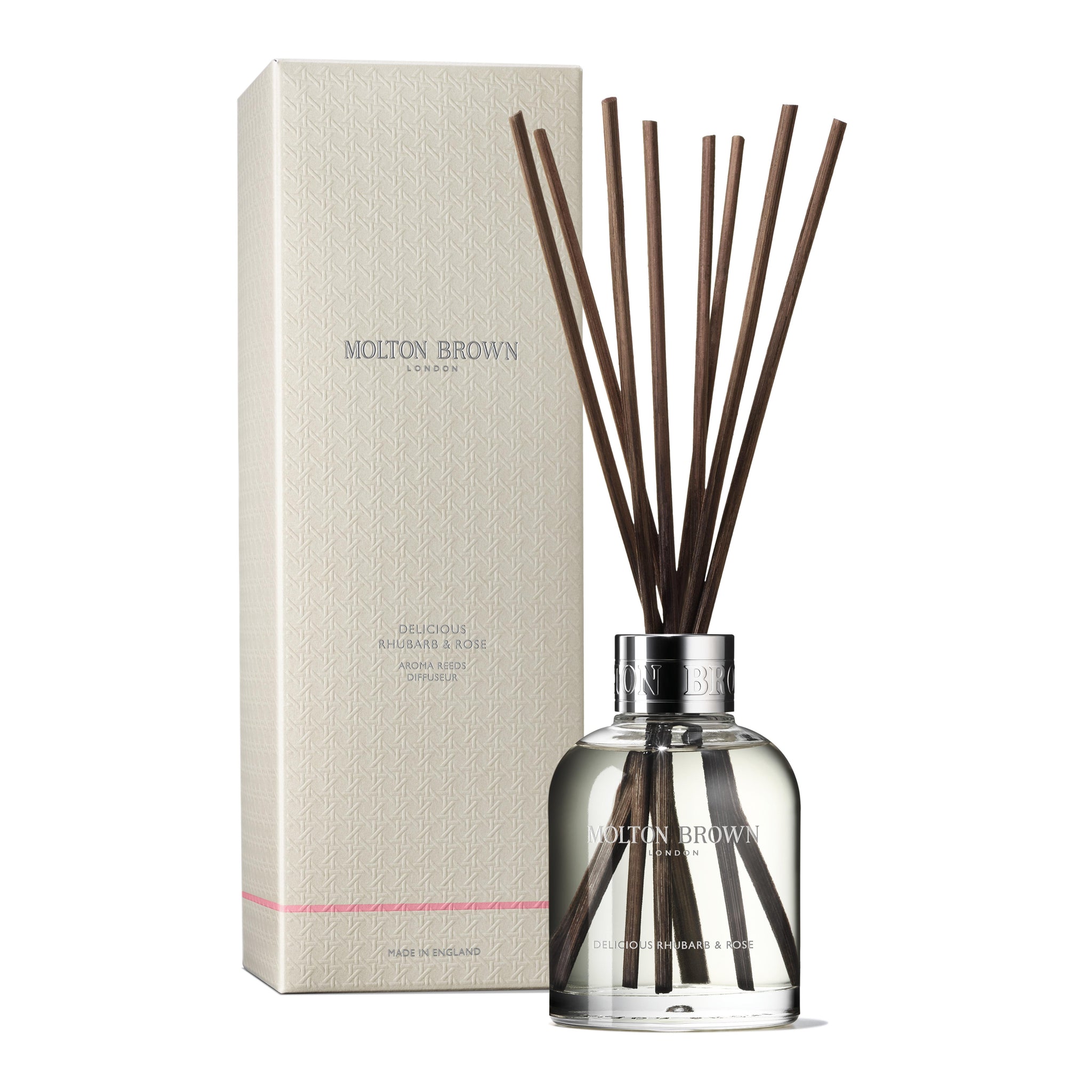 The MoltonBrown Cyprus Delicious Rhubarb & Rose Aroma Reeds 150ml comes in a clear glass bottle featuring the scent's name, presenting captivating citrus notes. Accompanied by its cream-colored box with textured patterns and the brand name, it creates an elegant home fragrance experience.