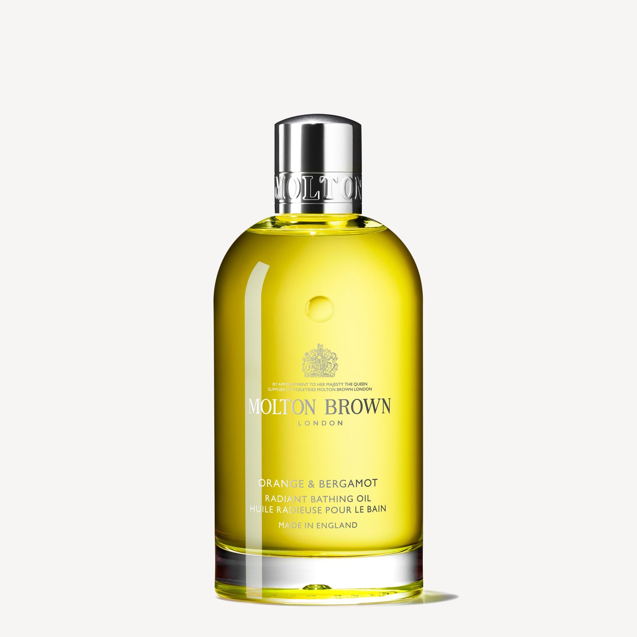 A bottle of MoltonBrown Cyprus Orange & Bergamot Radiant Bathing Oil 200ml comes infused with Sevillian orange oil for a radiant experience. Encased in clear glass, the yellow liquid gleams beneath a silver cap. Its label elegantly showcases the product name and origin, adding a touch of luxury to your bathing routine.