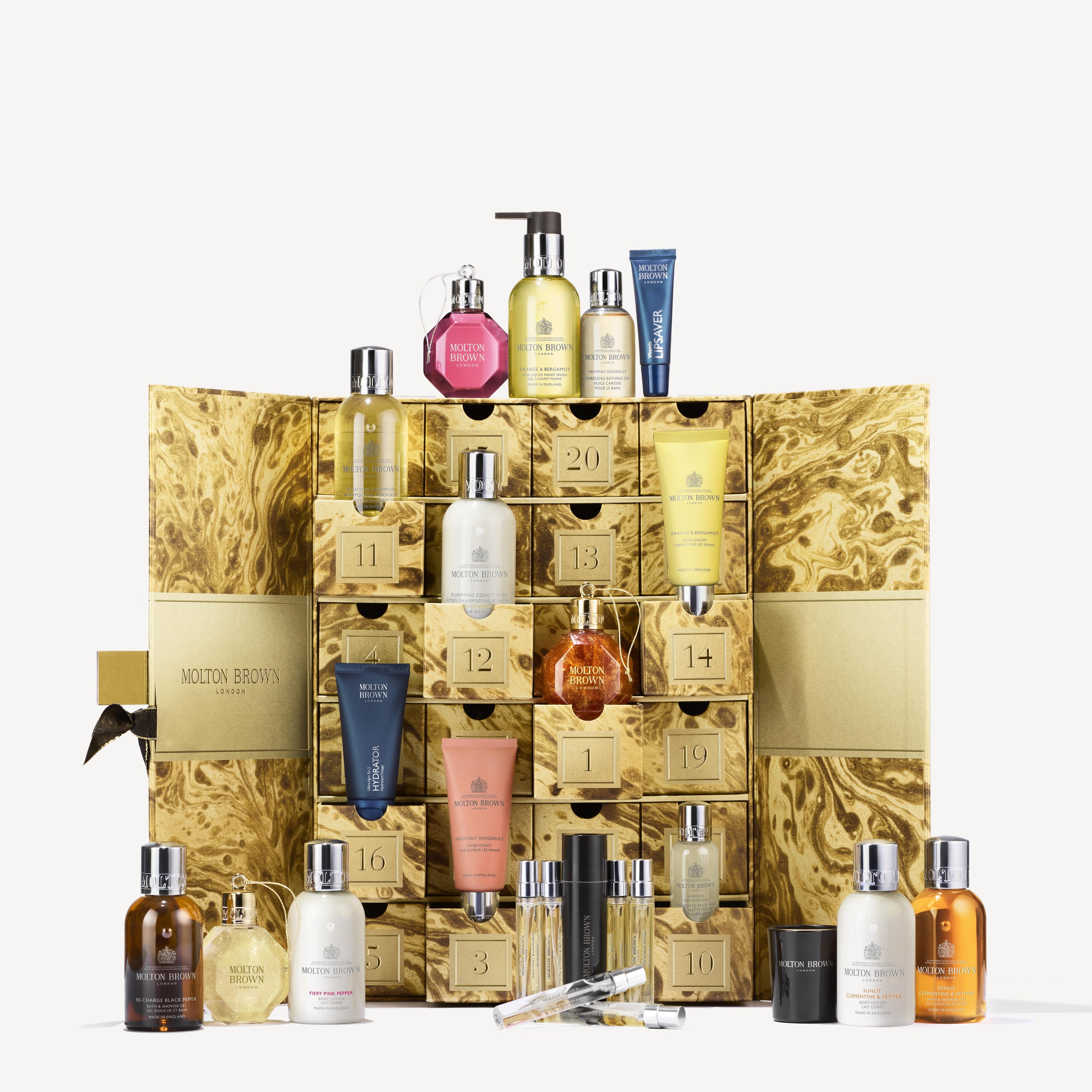 Explore the exclusive Advent Calendar by MoltonBrown Cyprus, featuring a stunning golden marble design similar to a masterpiece created by a marble artist. Hidden behind each numbered drawer are delightful surprises, such as luxurious fragrances, lotions, and bath products in charming petite bottles and tubes.