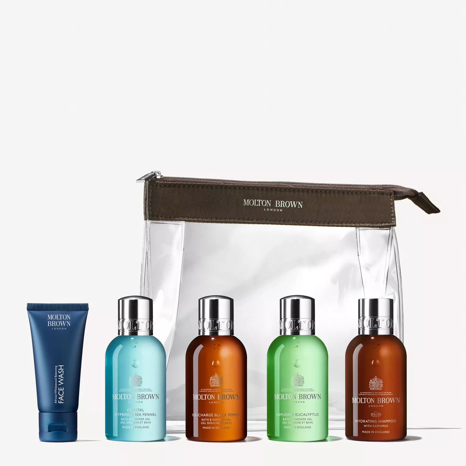 The Refreshed Adventurer Body & Hair Carry-On Bag from Molton Brown Cyprus includes face wash and four assorted body wash or shampoo bottles, neatly displayed with a transparent travel pouch and brown zipper. Ideal for your carry-on.