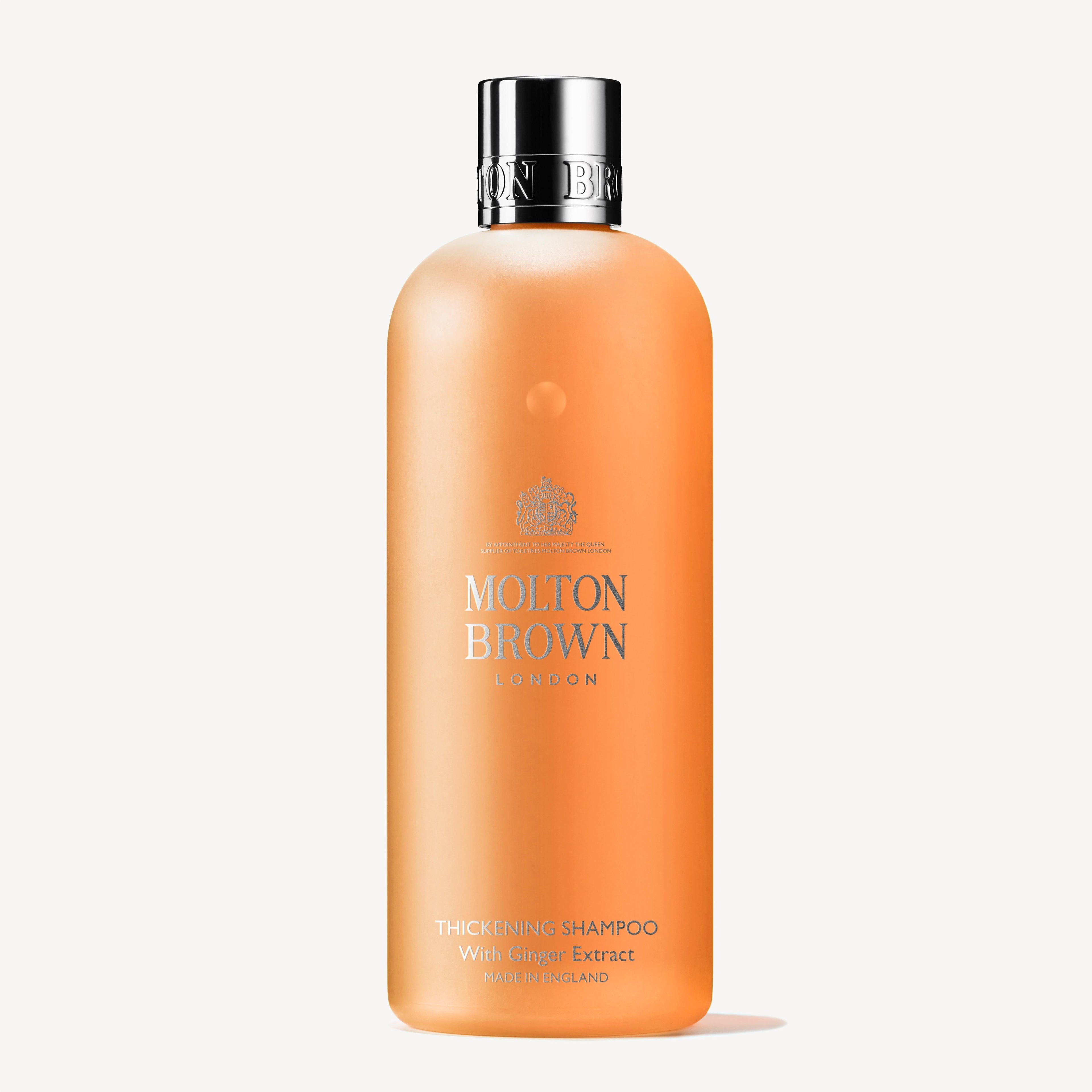 A bottle of MoltonBrown Cyprus Thickening Shampoo With Ginger Extract 300ml for fine or flat hair is displayed against a plain background. The orange bottle features a silver cap and text on the front.