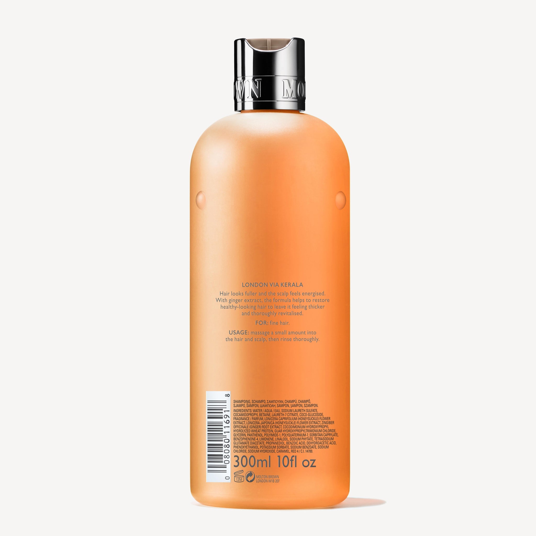 A 300ml bottle of orange body wash with a silver cap, featuring the label "London via Kerala" and emphasizing ingredients such as mango, ginger extract, and coconut. Designed for a luxurious and refreshing bathing experience that integrates seamlessly into your routine, similar to MoltonBrown Cyprus's Thickening Shampoo With Ginger Extract 300ml for fine hair.