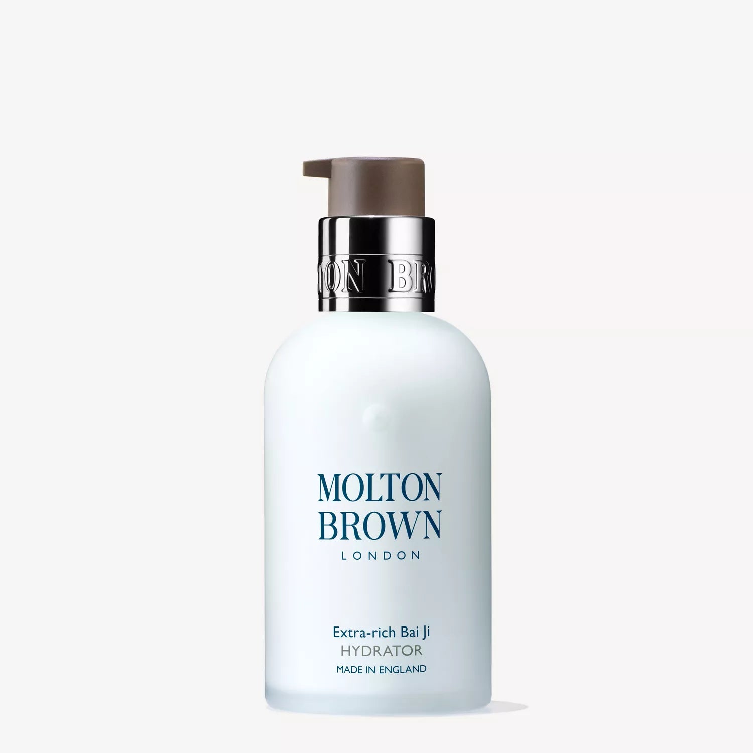 A white bottle of Molton Brown Cypruss Extra-rich Bai Ji Hydrator 100ml with a pump top features bai ji extract. The label states this luxurious moisturiser, enriched with macadamia seed oil for added nourishment, is made in England.