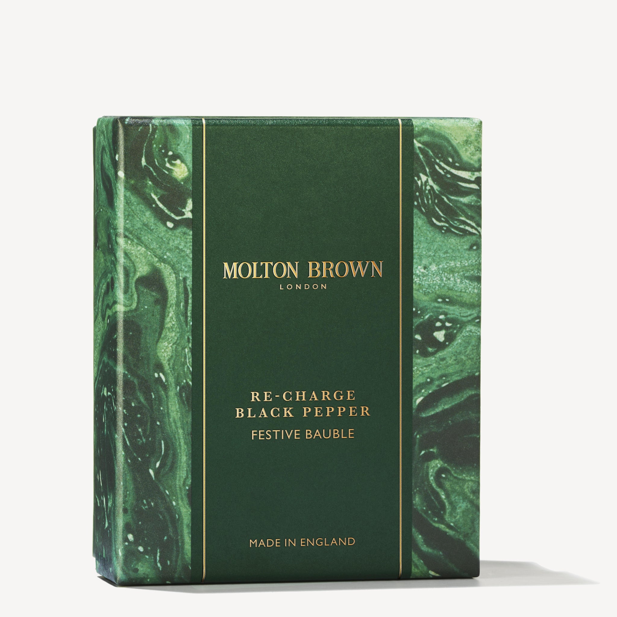 A green marbled box with gold MoltonBrown Cyprus text presents the Re-charge Black Pepper Festive Bauble. Infused with spicy coriander and black pepper, it provides a woody body wash experience. "Made in England" is elegantly inscribed at the bottom.