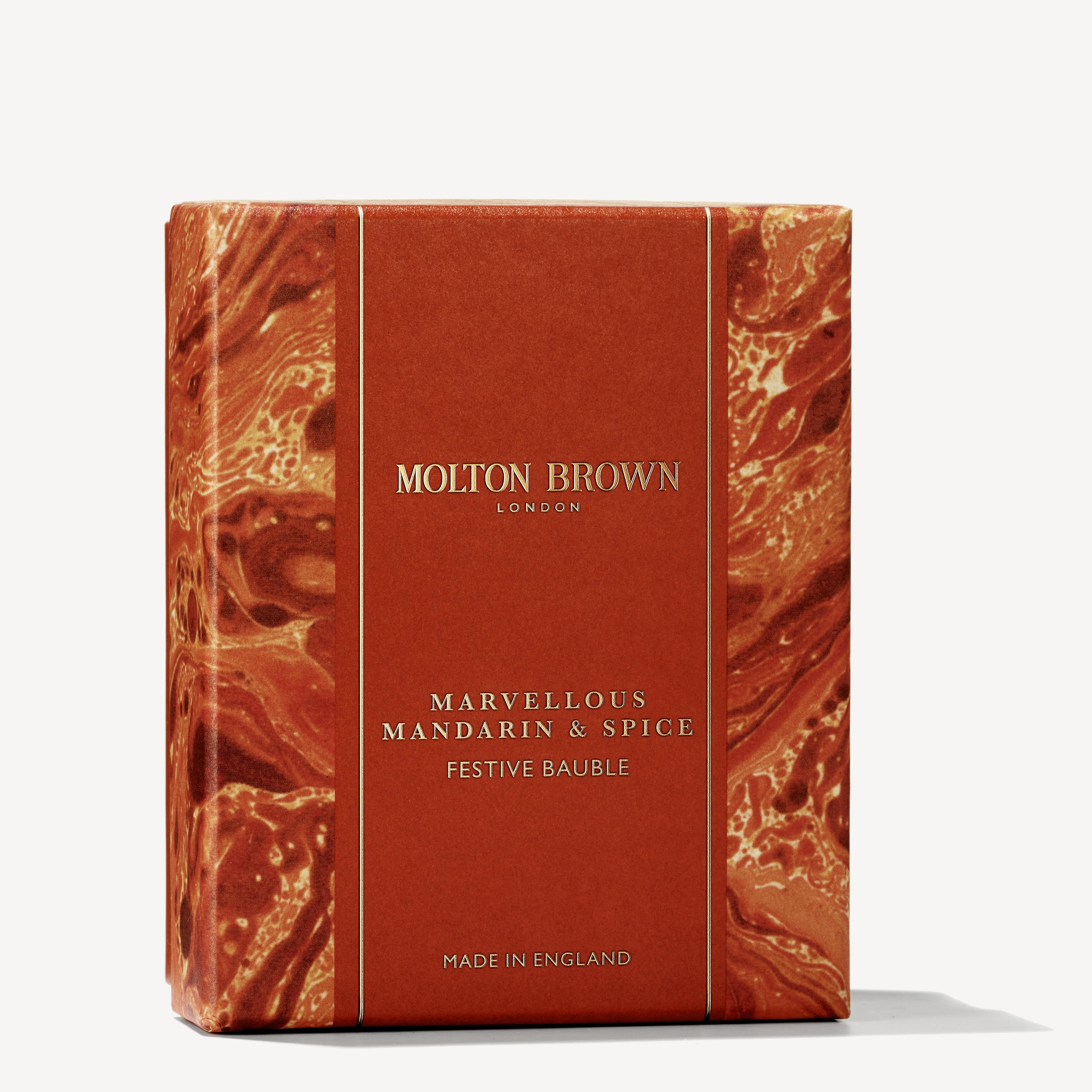 An intricately marbled orange and gold patterned square gift box from MoltonBrown Cyprus elegantly houses the Marvellous Mandarin & Spice Festive Bauble. Crafted in England, this piece captures a winter citrus charm, making it an ideal Christmas bauble or a lavish body wash indulgence.