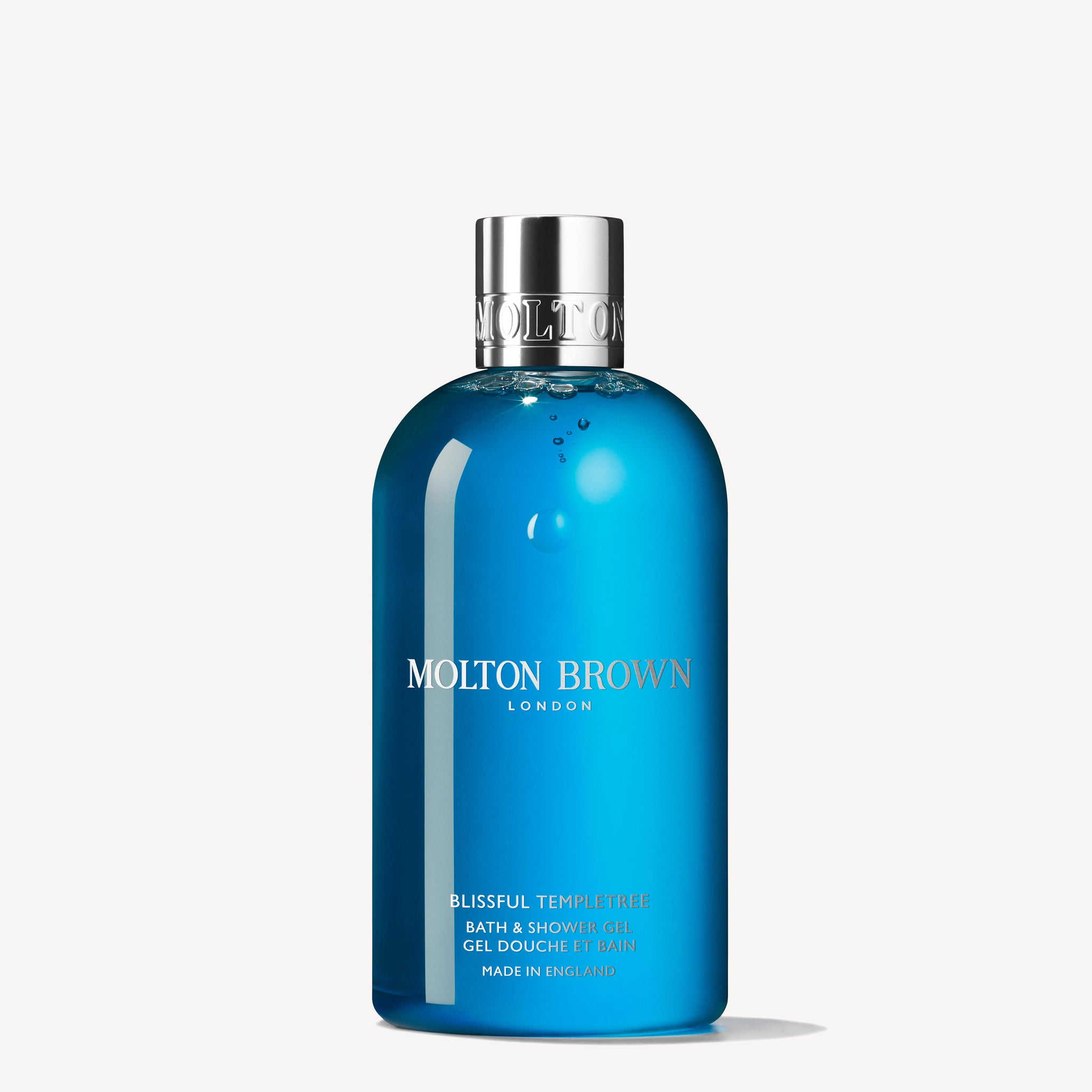 A 300ml bottle of MoltonBrown Cyprus Blissful Templetree Bath & Shower Gel, complete with a silver cap and label featuring the brand name and product details elegantly in white text. This luxurious body wash captivates with its fruity-floral notes for an enchanting bathing experience.