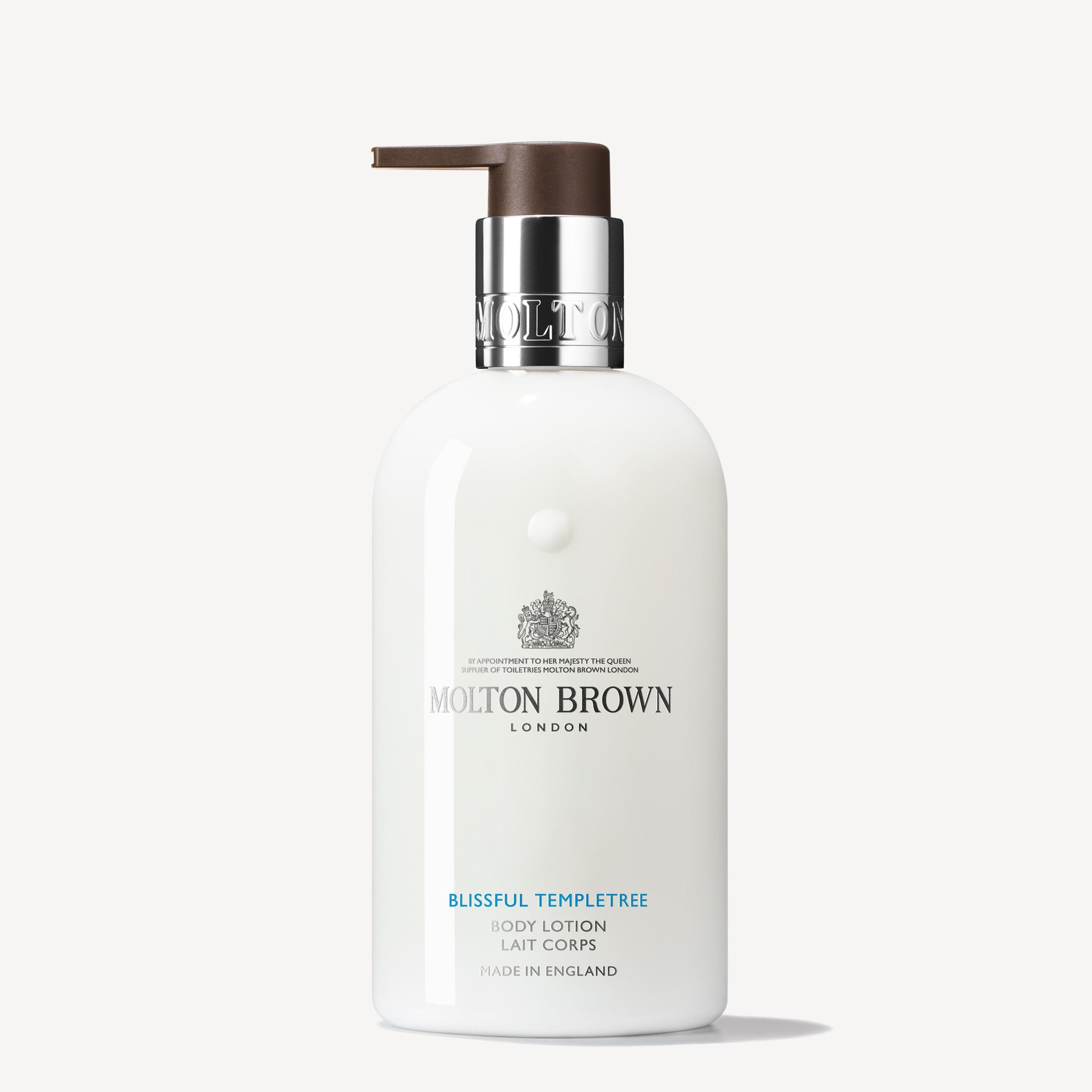 A sleek white bottle of MoltonBrown Cyprus Blissful Templetree Body Lotion, featuring a black pump dispenser, stands elegantly. The label displays the brand's logo and product name in stylish lettering, suggesting its floral fragrance against a simple light background.