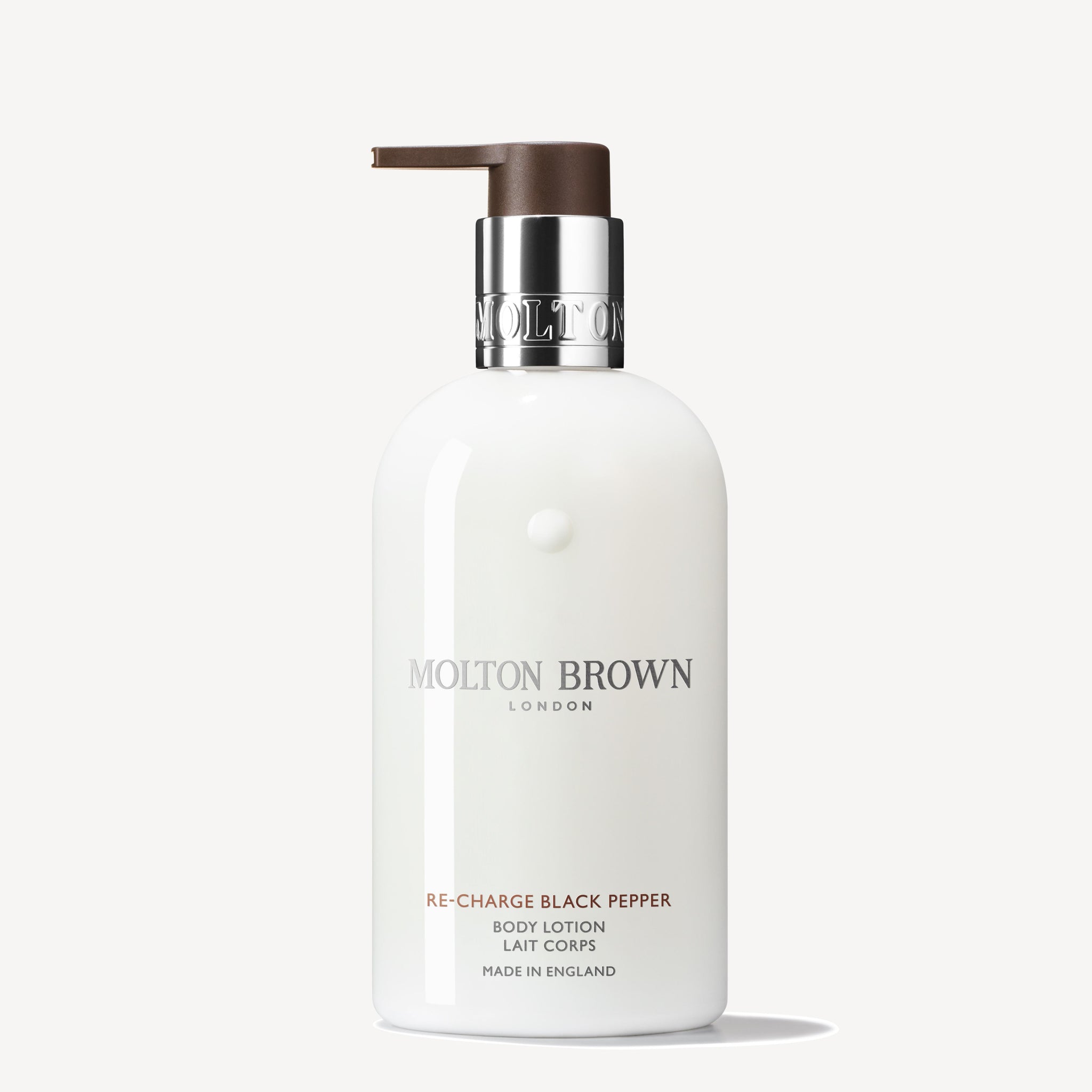 A 300ml bottle of Re-charge Black Pepper Body Lotion by MoltonBrown Cyprus, enriched with vetiver for an invigorating aroma. It includes a pump dispenser and a sleek design, prominently featuring the brand and product details on the label, crafted in England against a plain background.