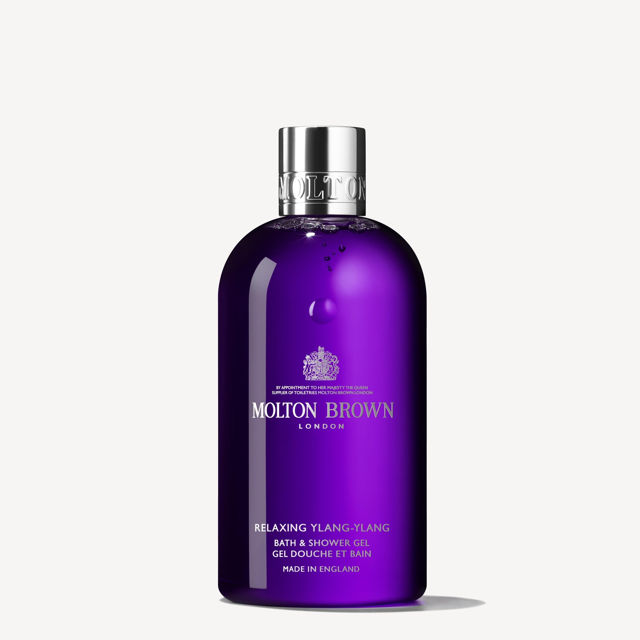 A purple bottle of MoltonBrown Cyprus Relaxing Ylang-Ylang Bath & Shower Gel 300ml, enhanced with soothing jasmine, rests against a white background. This body wash features a gleaming silver cap and prominently displays the brand and product details.