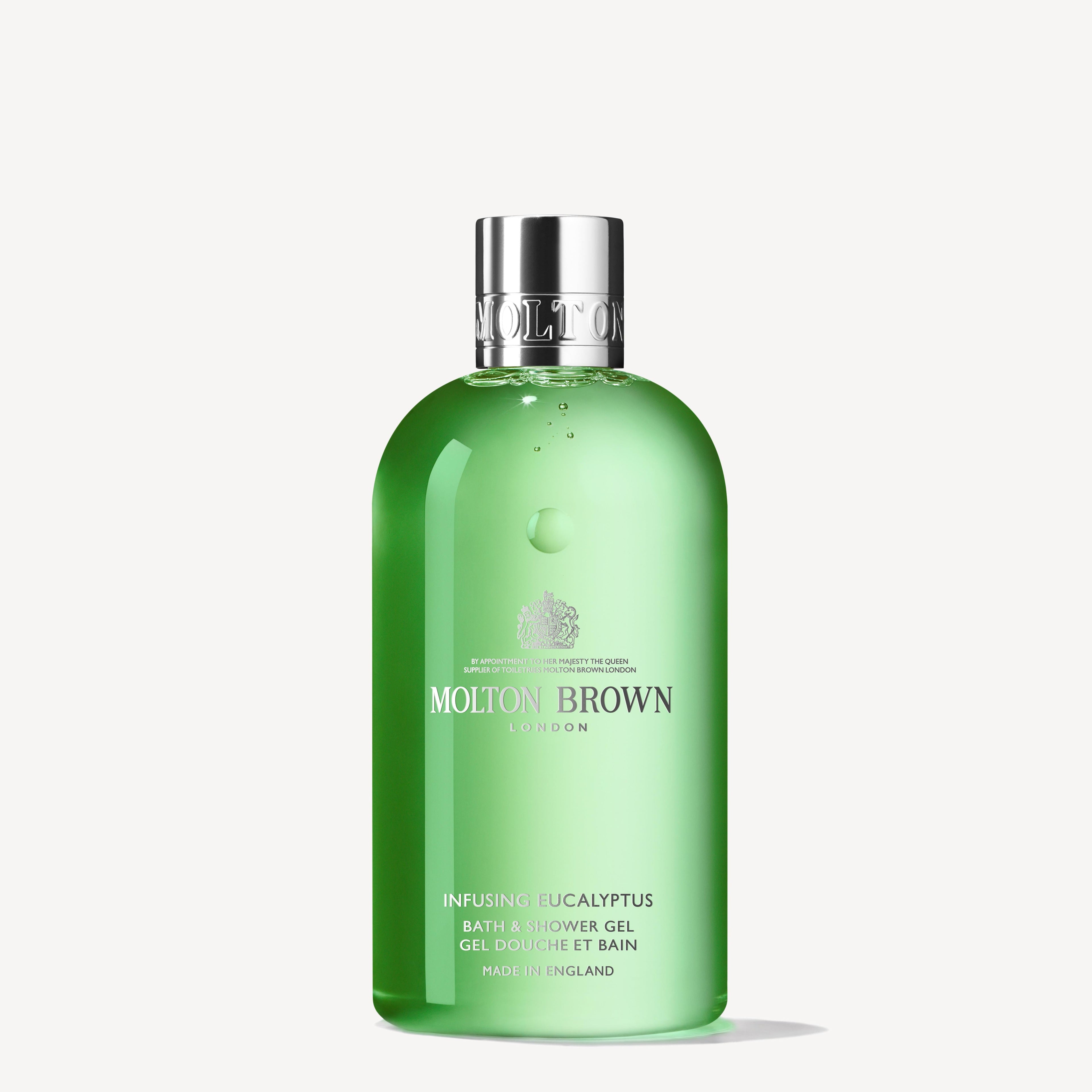 A green bottle of Infusing Eucalyptus Bath & Shower Gel 300ml from MoltonBrown Cyprus, featuring a clear cap. The label stylishly presents the brand and product information in white text on a simple, light background. The fresh scent of wild mint harmonizes perfectly with the eucalyptus fragrance.