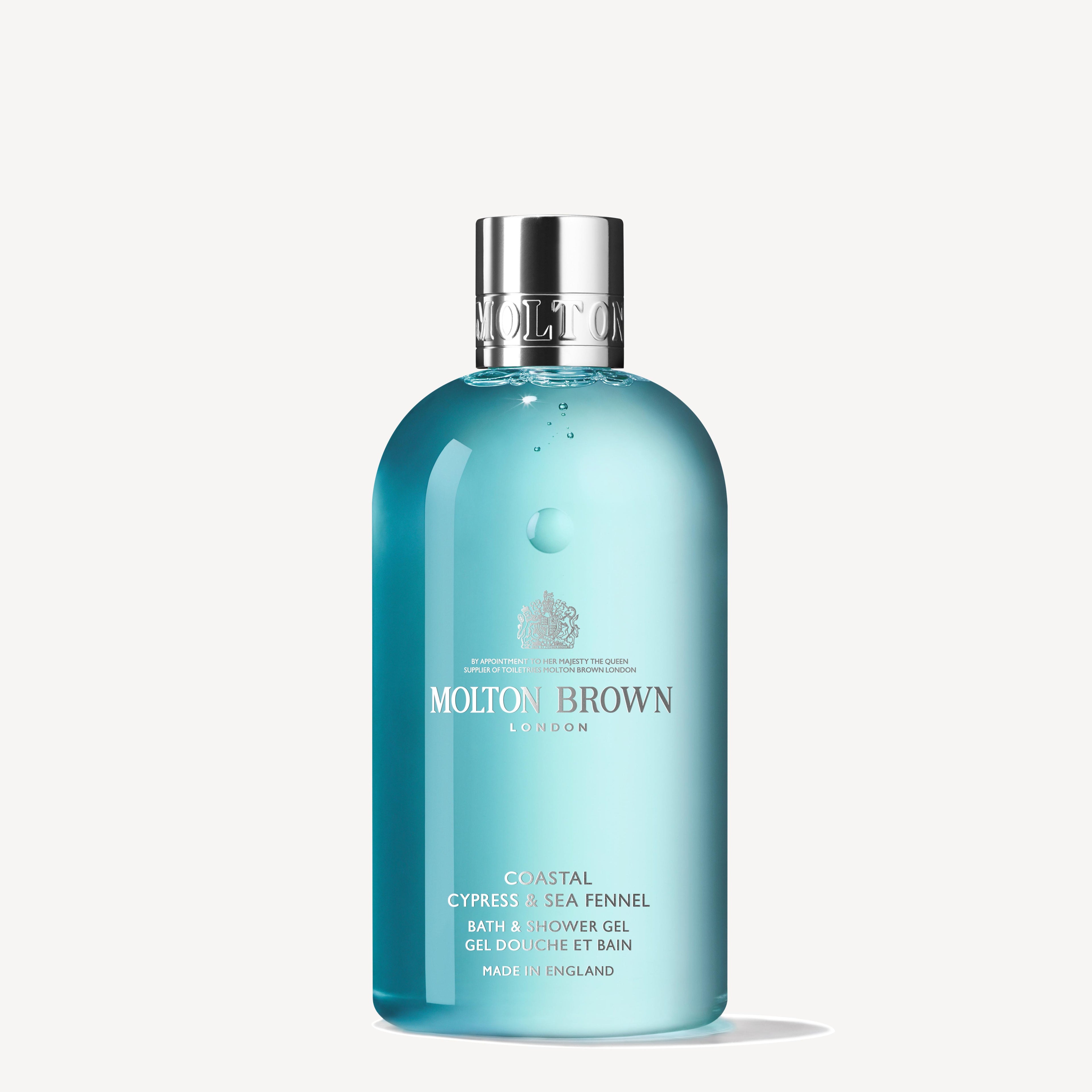 A MoltonBrown Cyprus Coastal Cypress & Sea Fennel Bath & Shower Gel in blue, topped with a silver cap. The label features white text and a crest logo on a plain white background.