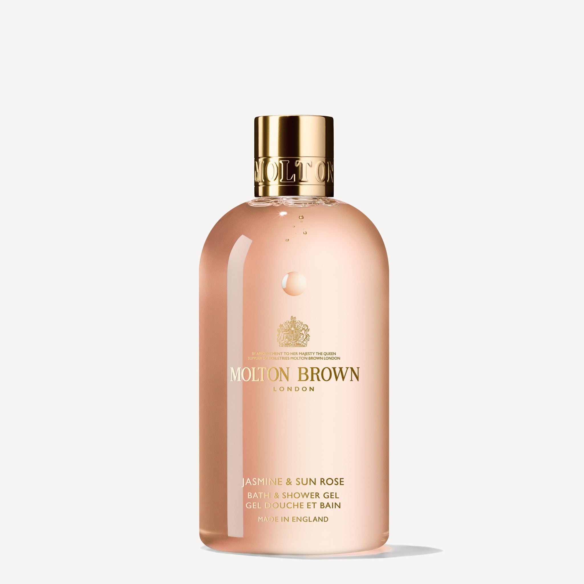 The MoltonBrown Cyprus Jasmine & Sun Rose Bath & Shower Gel 300ml epitomizes elegance with its transparent bottle, adorned in a pink tint and featuring gold lettering and a gold cap. Enriched with jasmine, its refined label enhances the luxurious allure of this exquisite shower gel.