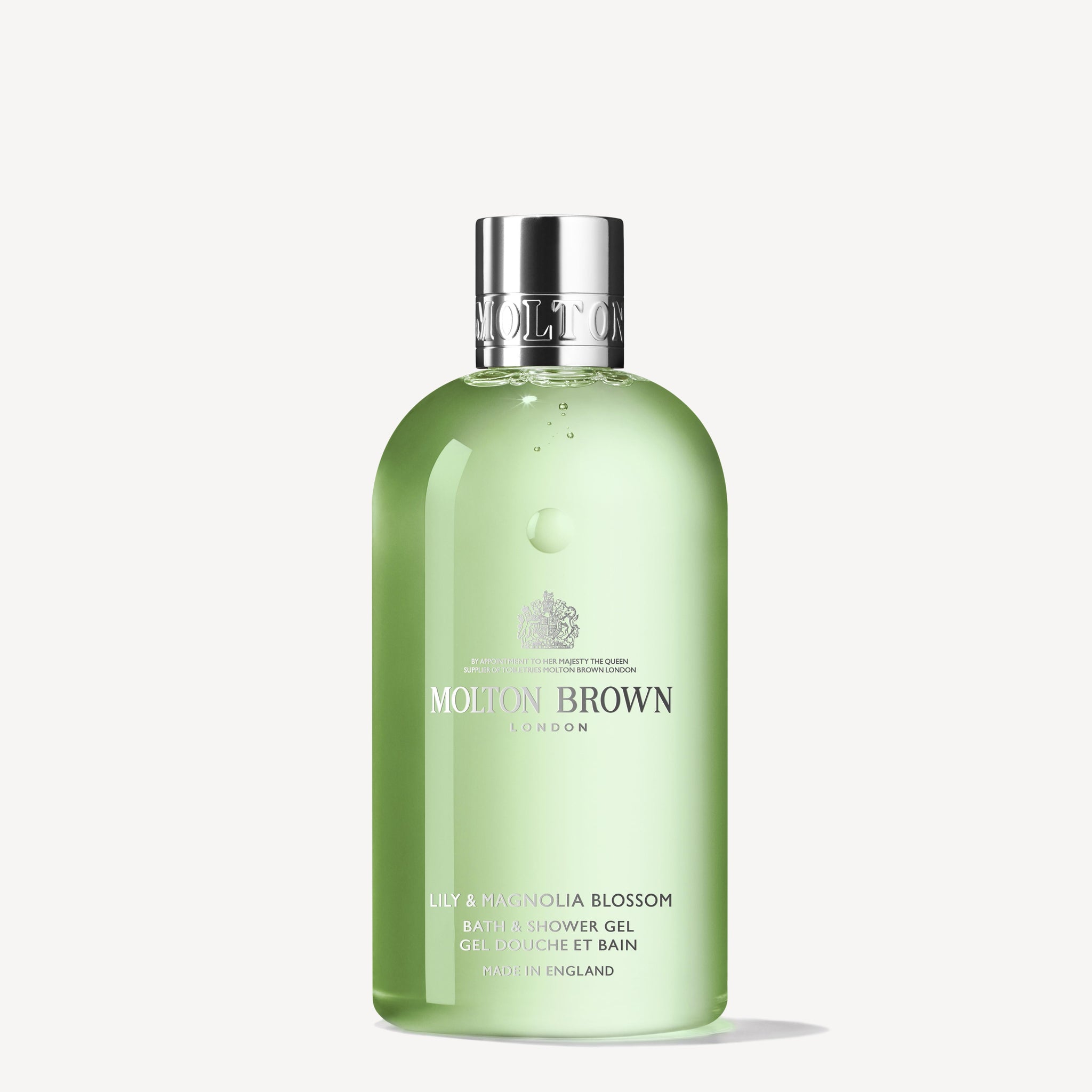 A 300ml bottle of MoltonBrown Cyprus Lily & Magnolia Blossom Bath & Shower Gel, featuring a silver cap and green packaging. The brand logo and product details are displayed in white text on the front. Enriched with lily of the valley notes, it offers a captivating floral experience.