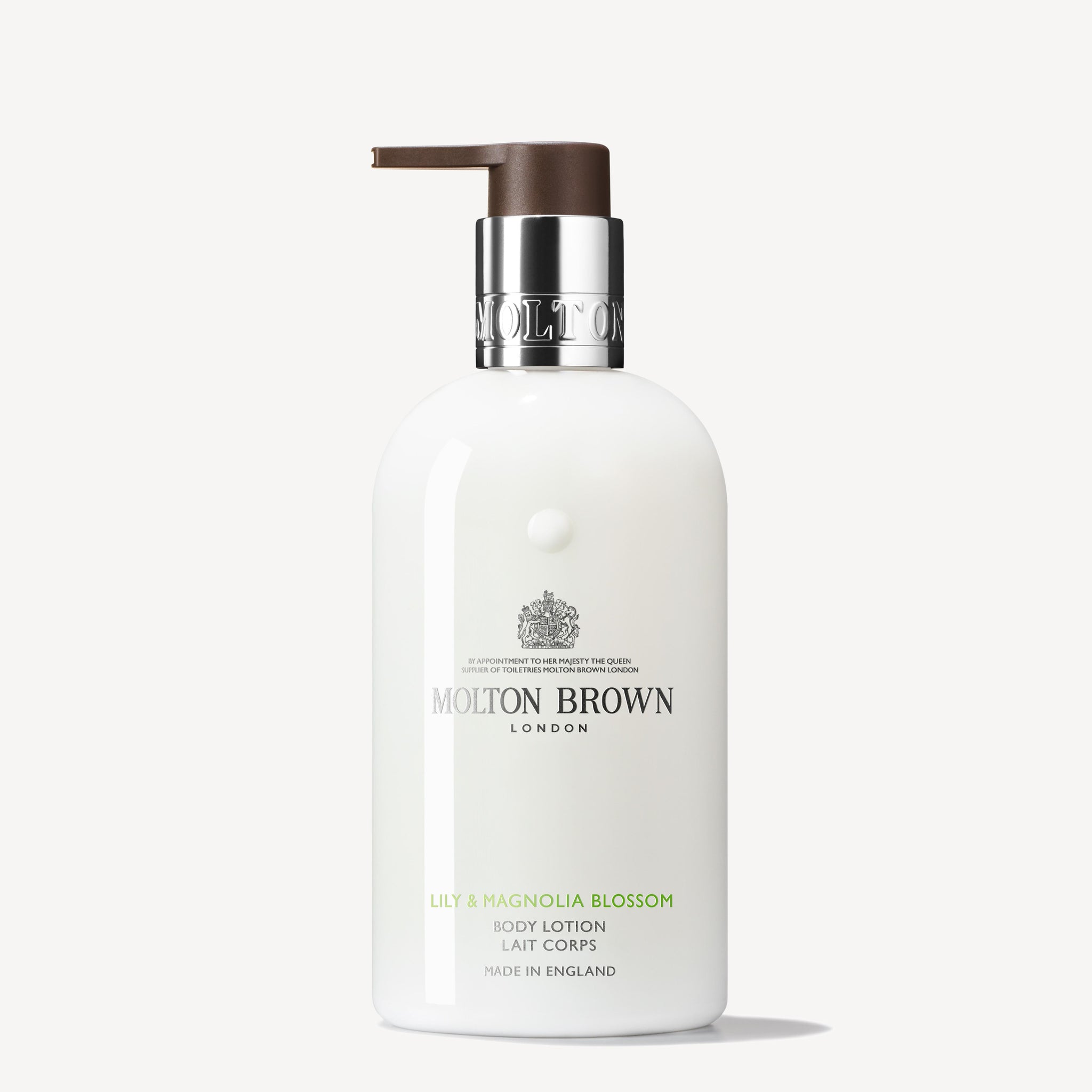 The MoltonBrown Cyprus Lily & Magnolia Blossom Body Lotion 300ml exudes luxury, housed in a sleek white cylindrical bottle with a sophisticated dark brown pump. The brand logo and product details elegantly embellish the front, making it a stylish complement to your skincare routine.