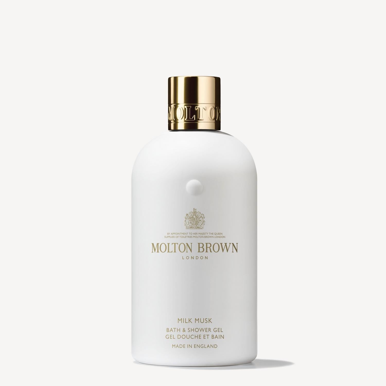 A bottle of MoltonBrown Cyprus Milk Musk Bath & Shower Gel 300ml, showcasing elegant white design with subtle pear and gold accents, is set against a plain background.