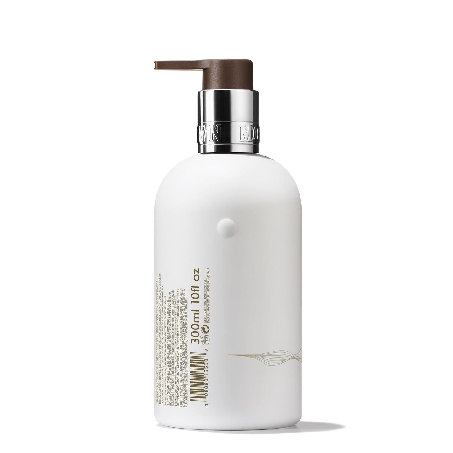 A bottle from MoltonBrown Cyprus, featuring a sleek white design with a brown pump and a silver band around the neck, stands upright. It is labeled with text and measurement details, containing 300 ml of Milk Musk Body Lotion.