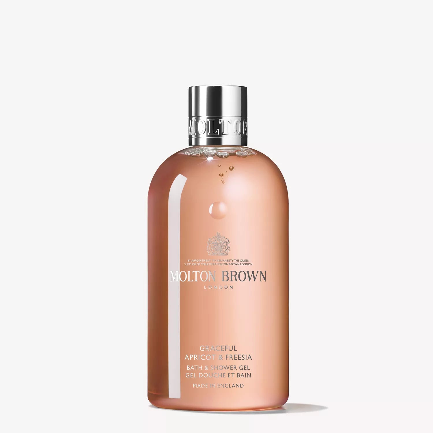 A bottle of MoltonBrown Cyprus Gift Product 2 captures the essence of an English orchard. The transparent container reveals a floral-fruity, peachy-pink liquid inside, topped with a silver cap and adorned with elegant typography on its label.