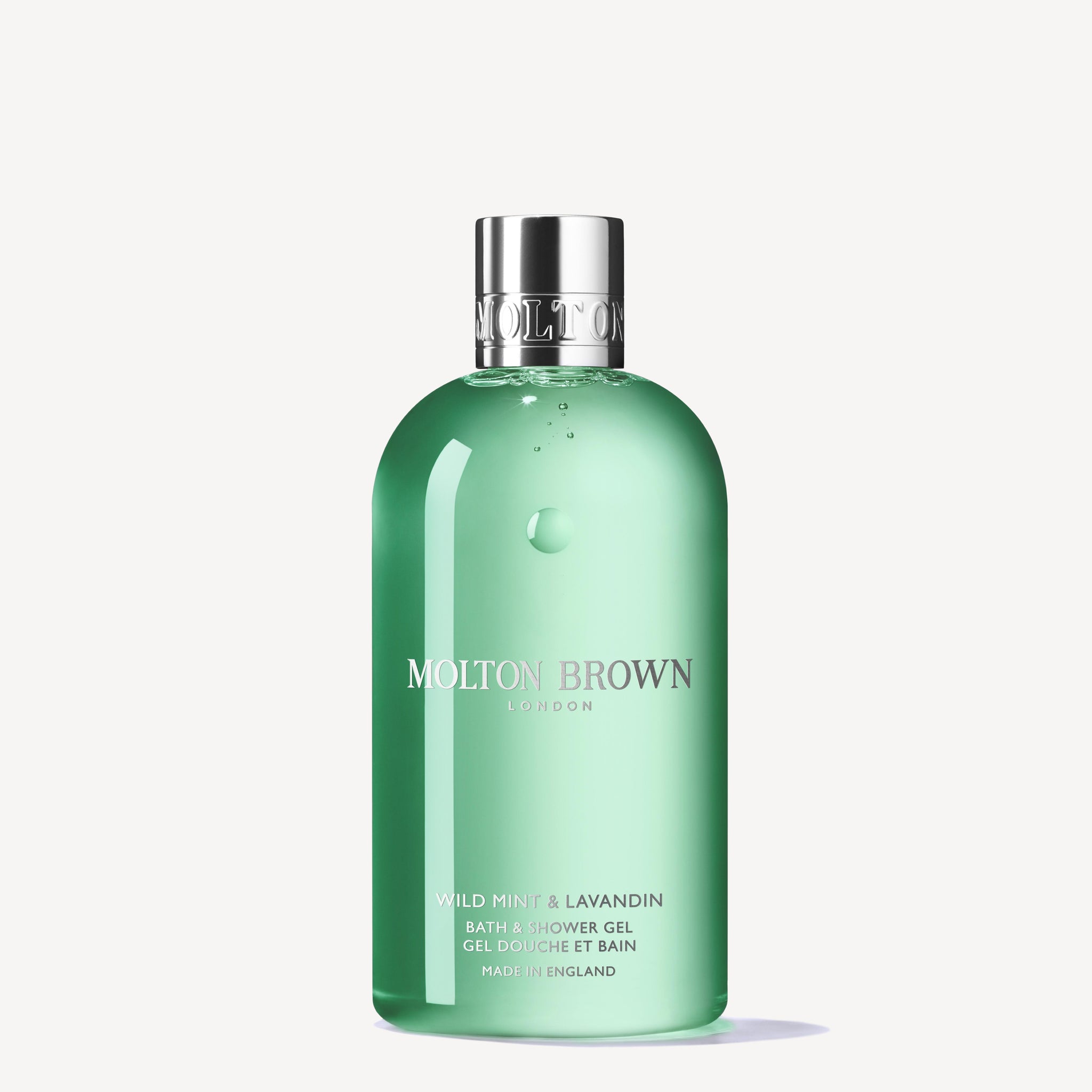 A 300ml bottle of MoltonBrown Cyprus Wild Mint & Lavandin Bath & Shower Gel features an infusion of wild mint, lavandin, and orris root. The gel is green, topped with a silver cap, and showcases elegantly printed product details on the front.