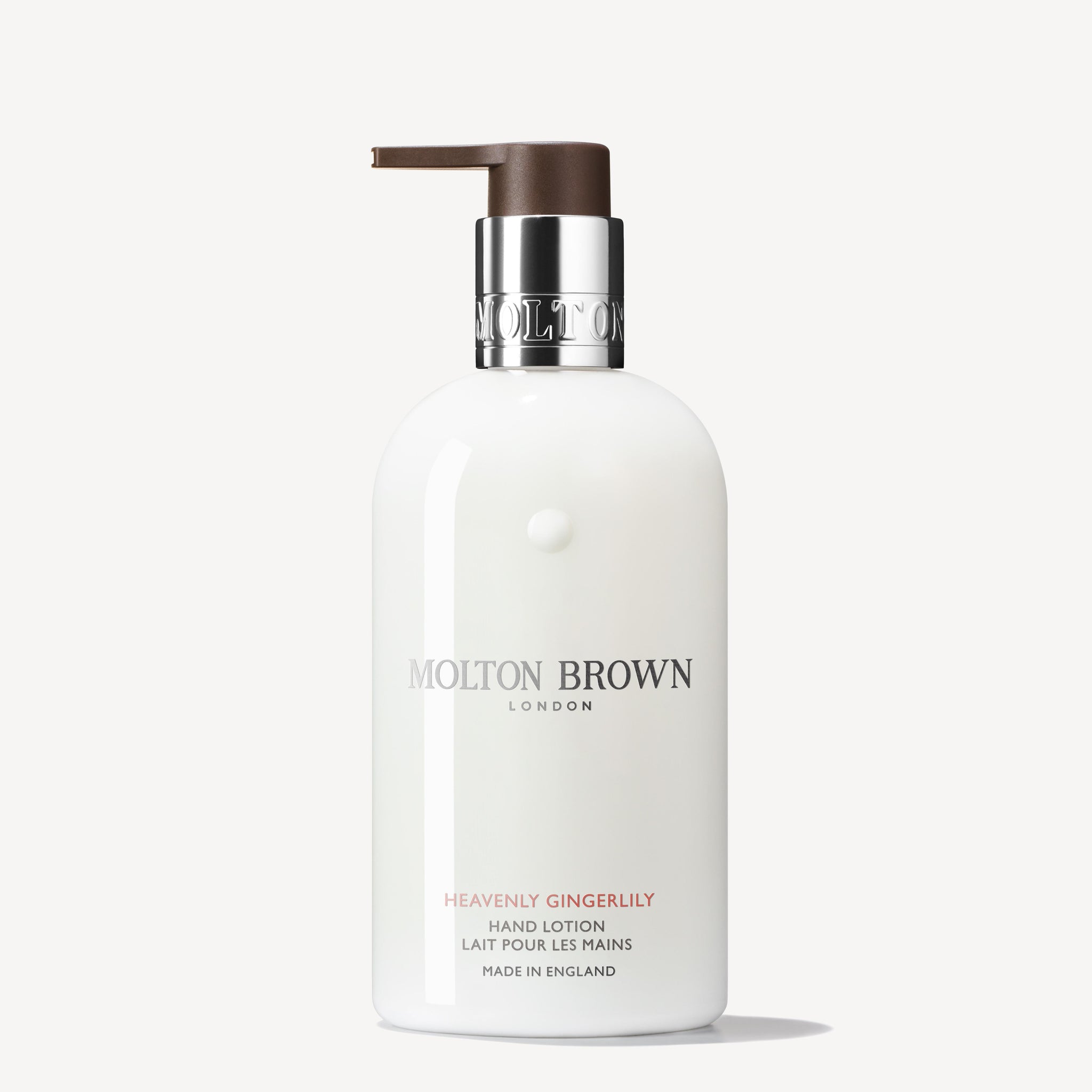 A 300ml bottle of MoltonBrown Cyprus Heavenly Gingerlily Hand Lotion with a pump dispenser, offering an exotic fragrance. The bottle has a white label adorned with silver and light brown text, featuring the brand logo and product details presented in both English and French.