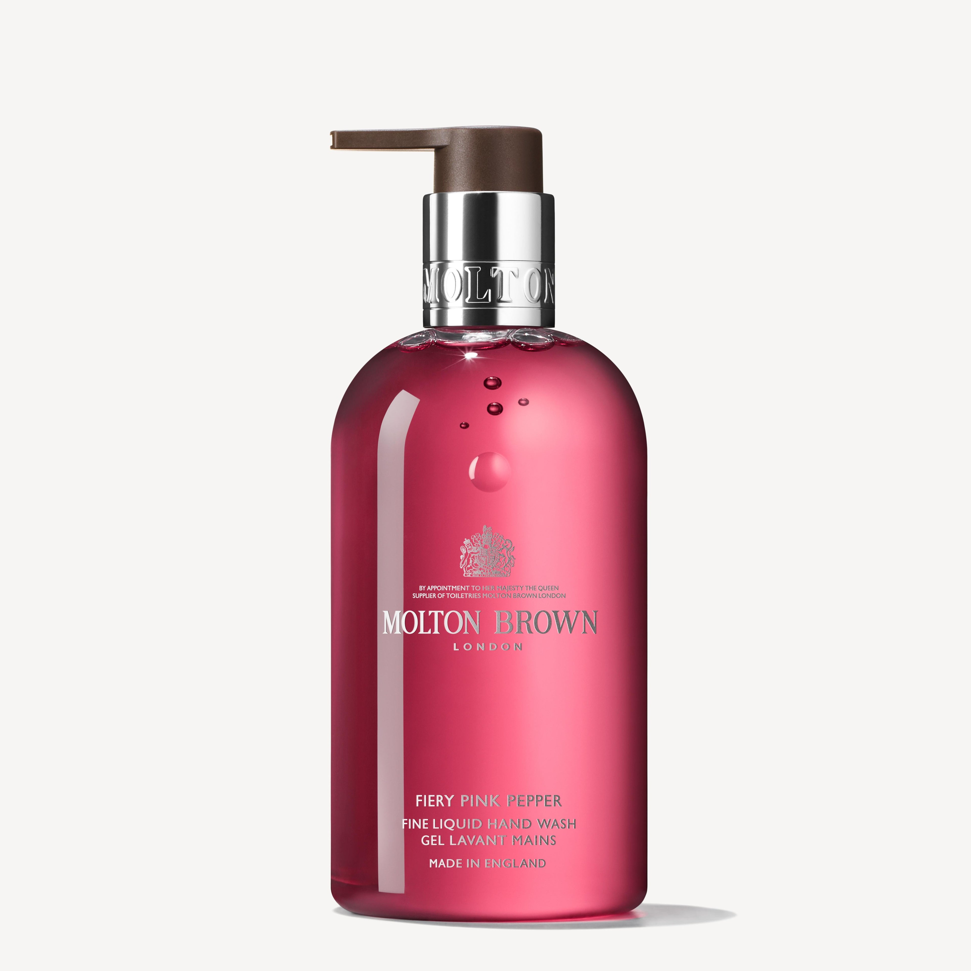 A 300ml bottle of MoltonBrown Cyprus Fiery Pink Pepper Fine Liquid Hand Wash with a hint of ginger. The clear pink bottle adorned with white text and complemented by a brown pump adds an exotic touch to your cleansing routine.