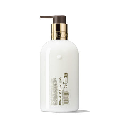 A luxurious Marvellous Mandarin & Spice Hand Lotion from MoltonBrown Cyprus, packaged in a white 300ml pump bottle with a gold top. The bottle features a label with barcode, displaying its capacity of 10.1 fl oz.