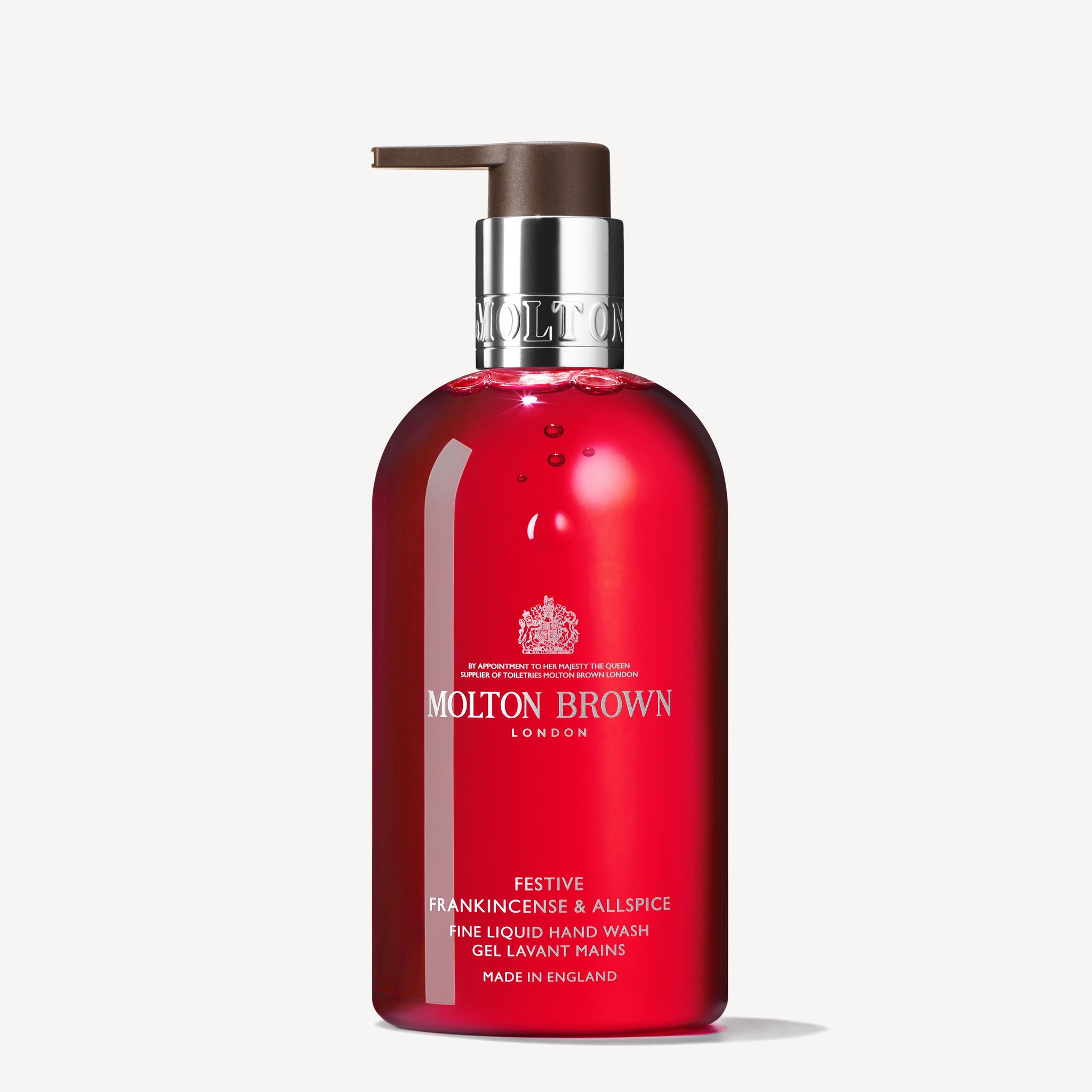 A 300ml bottle of MoltonBrown Cyprus Festive Frankincense & Allspice Fine Liquid Hand Wash, infused with spiced frankincense, comes in a red bottle with a pump dispenser and features the product name and details in white text on the label.