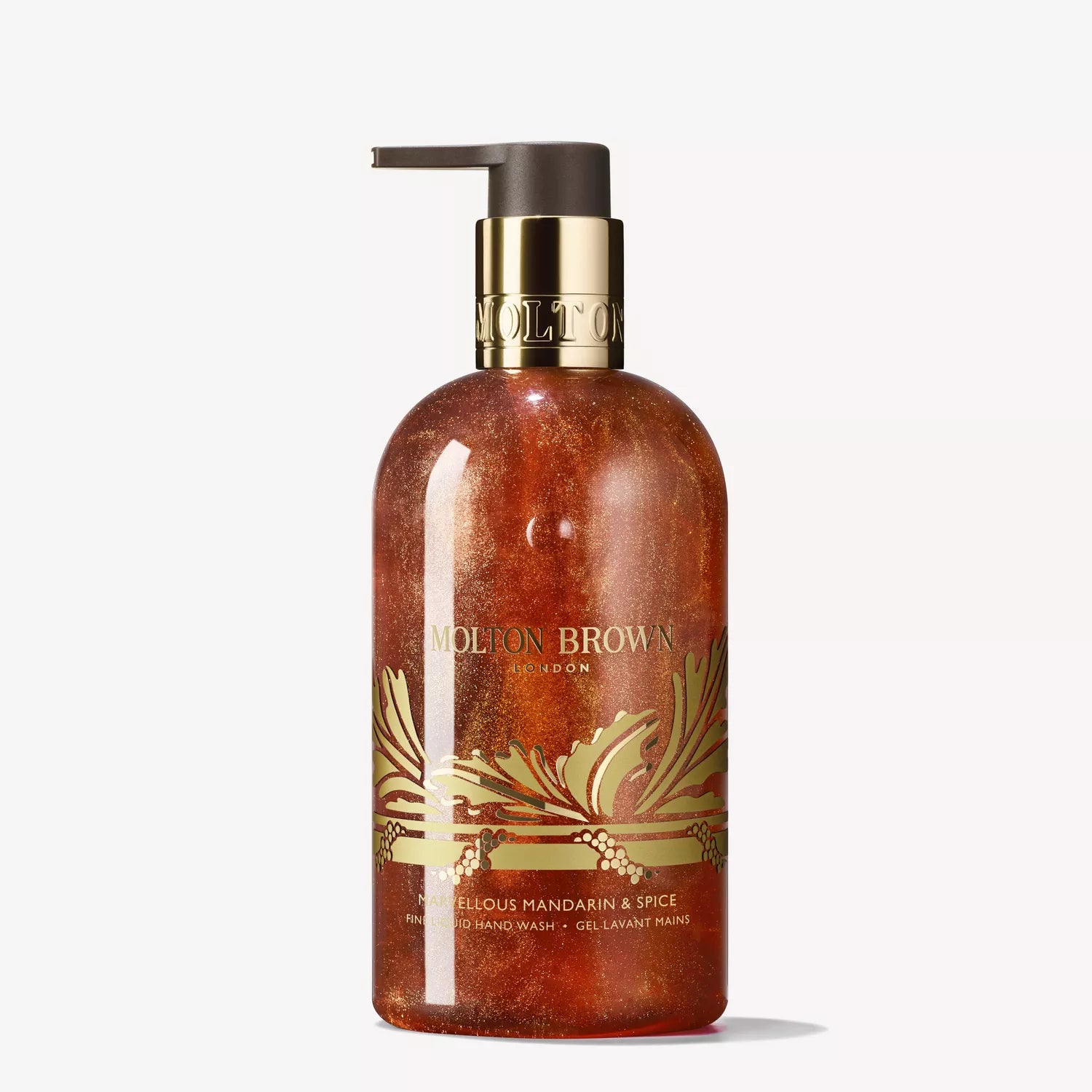 A clear pump bottle of MoltonBrown Cyprus Marvellous Mandarin & Spice Fine Liquid Hand Wash 300ml, featuring orange gel, a gold floral design, and a gold pump top. Label shows MoltonBrown Cyprus and product name.