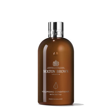 A brown bottle of MoltonBrown Cyprus Volumising Conditioner with Nettle, crafted for fine hair and topped with a silver cap. The bottle includes the text "Made in England" and is displayed against a plain white background, offering weightless volume and revitalized strands.