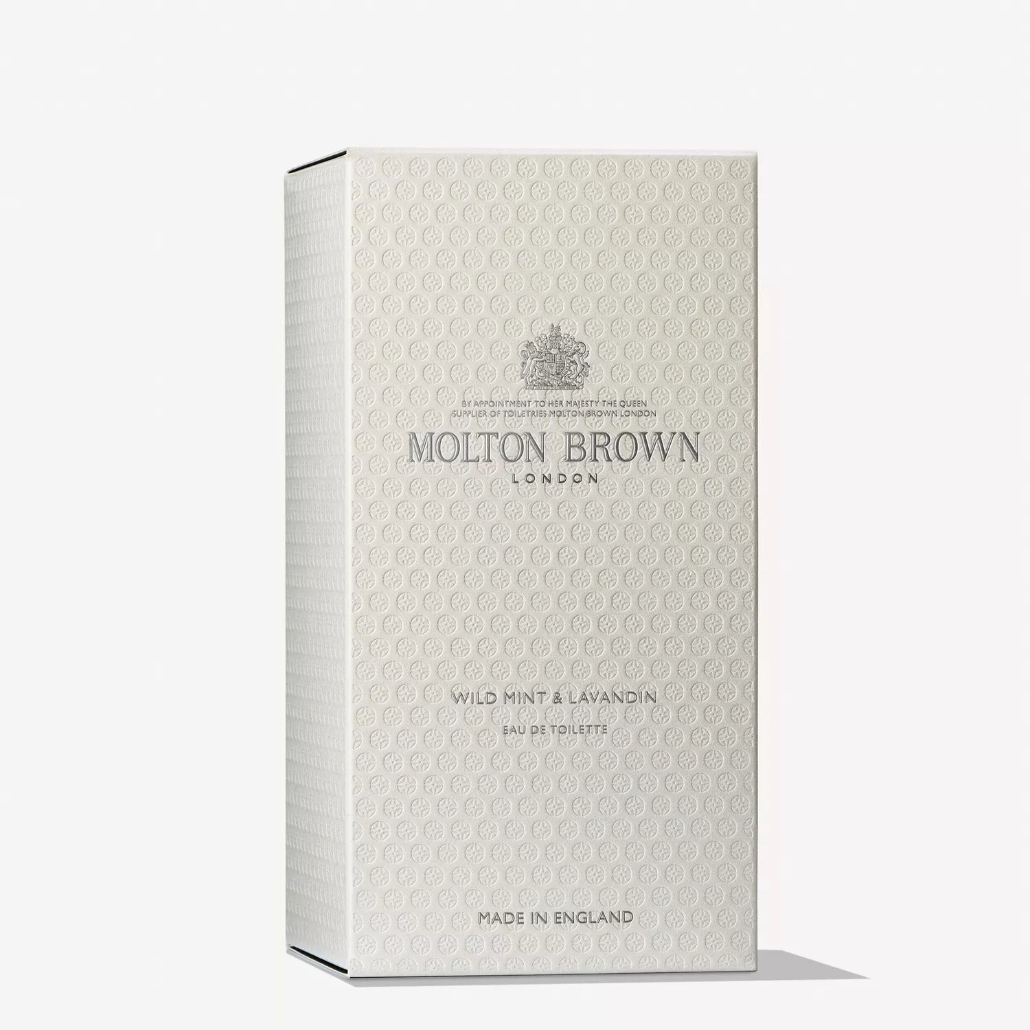 The textured rectangular box with embossed detailing showcases the MoltonBrown Cyprus logo and Wild Mint & Lavandin Eau de Toilette 100ml. The light gray packaging, labeled Made in England, subtly hints at tonka bean notes, exuding sophistication.