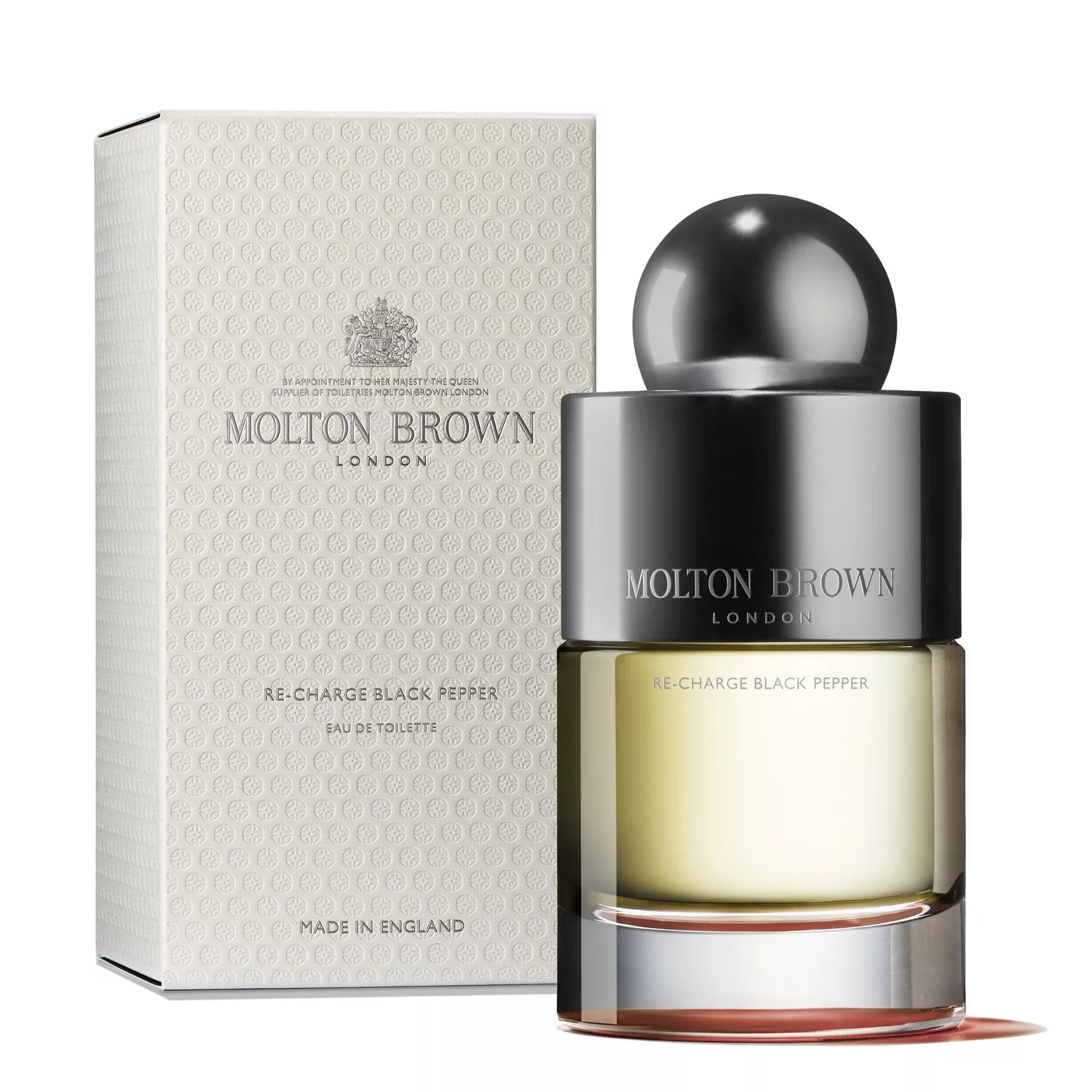 A bottle of Molton Brown Cyprus Re-Charge Black Pepper Eau de Toilette 100ml stands elegantly beside its textured box, featuring a dark spherical cap and a light-colored box with brand details and Made in England, capturing the essence of this invigorating fragrance.