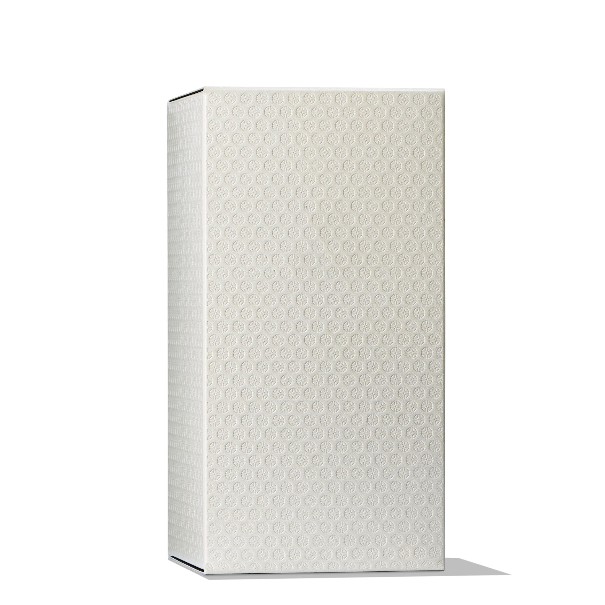 A tall, rectangular white box with subtle embossed patterns reminiscent of the MoltonBrown Cyprus Re-charge Black Pepper Eau de Toilette 100ml. It stands upright against a plain white background, casting a soft shadow to its right, evoking the elegance and allure of this fine fragrance.