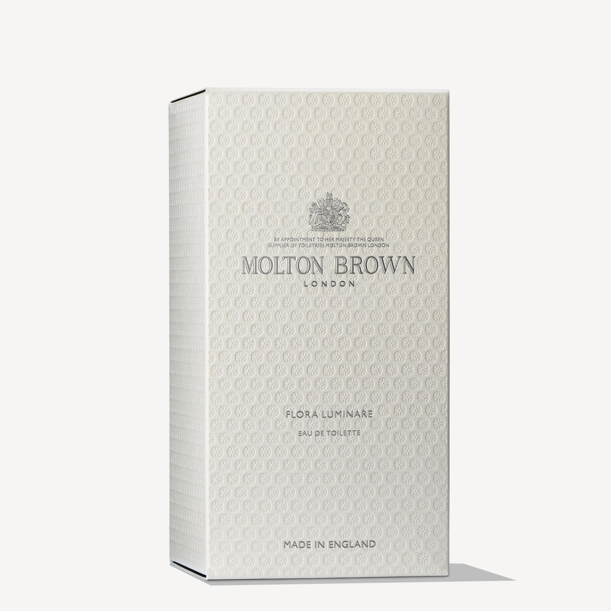 A textured light beige box features the silver text MoltonBrown Cyprus and Flora Luminare Eau de Toilette 100ml. The sophisticated, minimalistic design is enriched with subtle Polynesian frangipani notes, making it an elegant selection labeled Made in England.